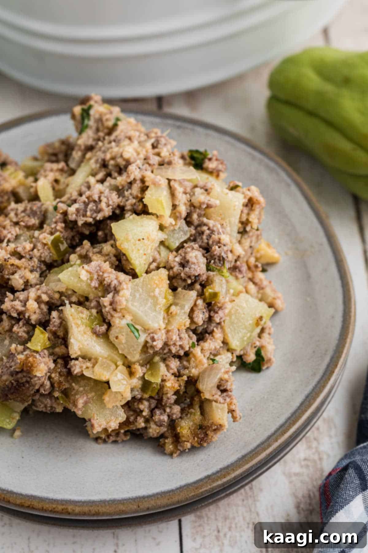 Close up of a dished up portion of mirliton dressing, garnished with fresh parsley.