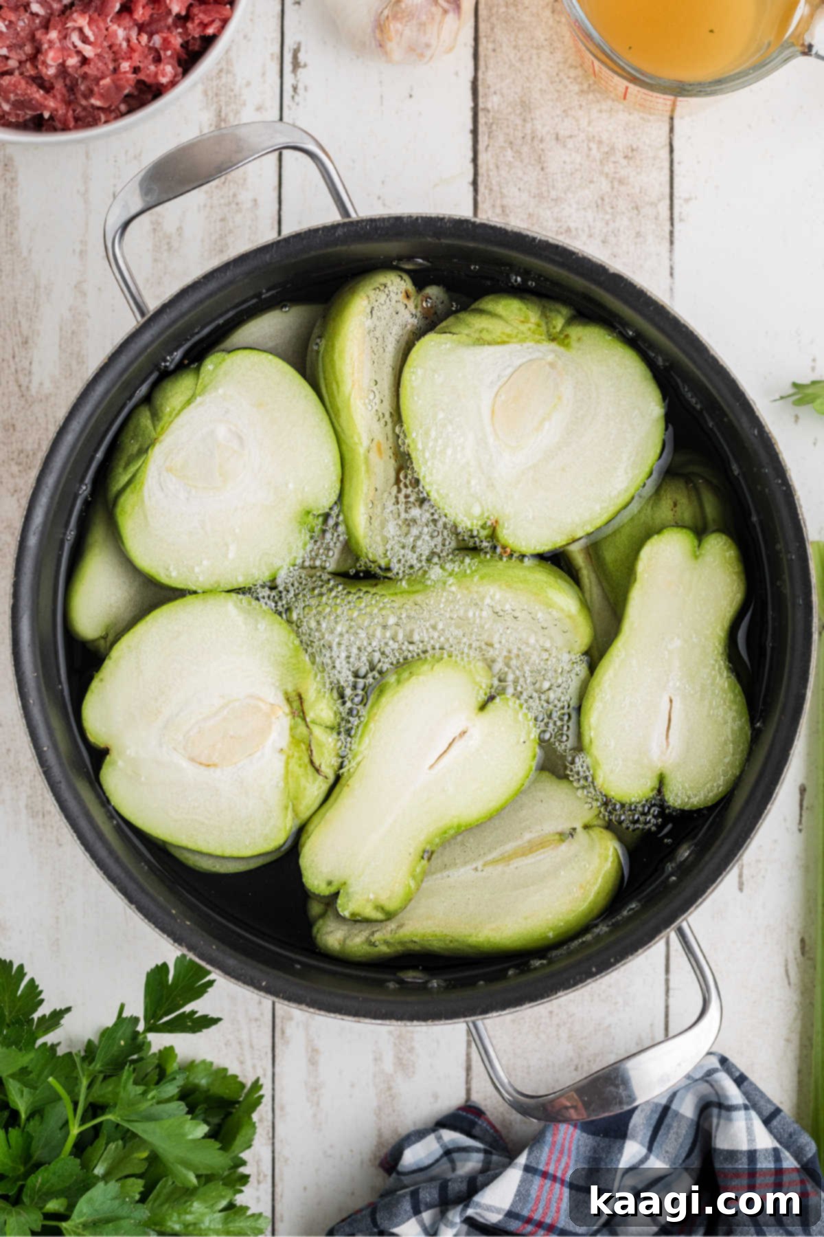 A pot with mirlitons and water boiling on the stove.