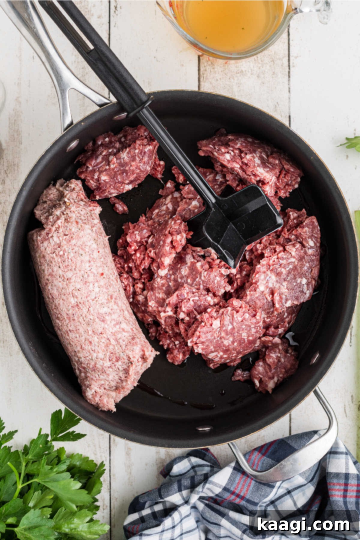 Ground meat and pork sausage browning in a large skillet.
