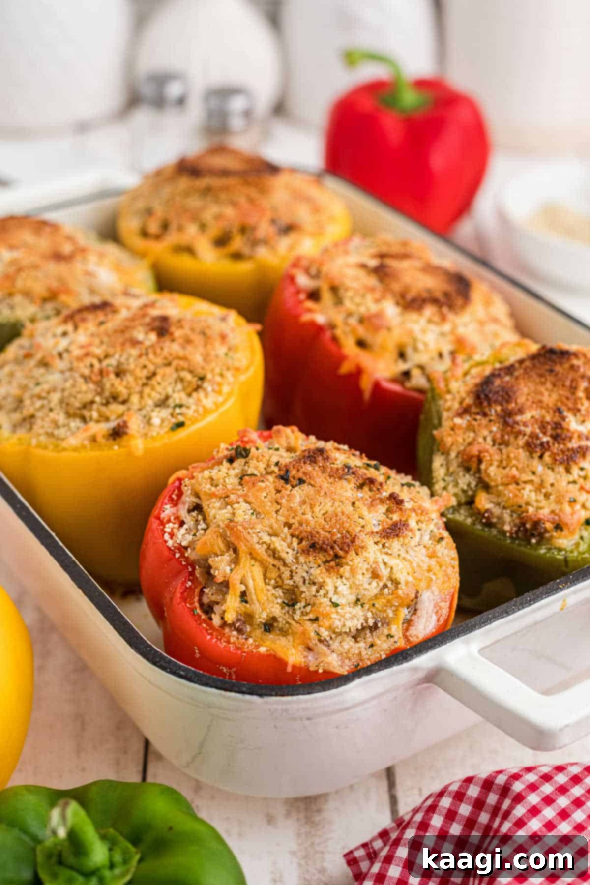 Bell Pepper Boats 2 A baking dish with golden-brown stuffed bell peppers, topped with seasoned breadcrumbs and melted cheese.