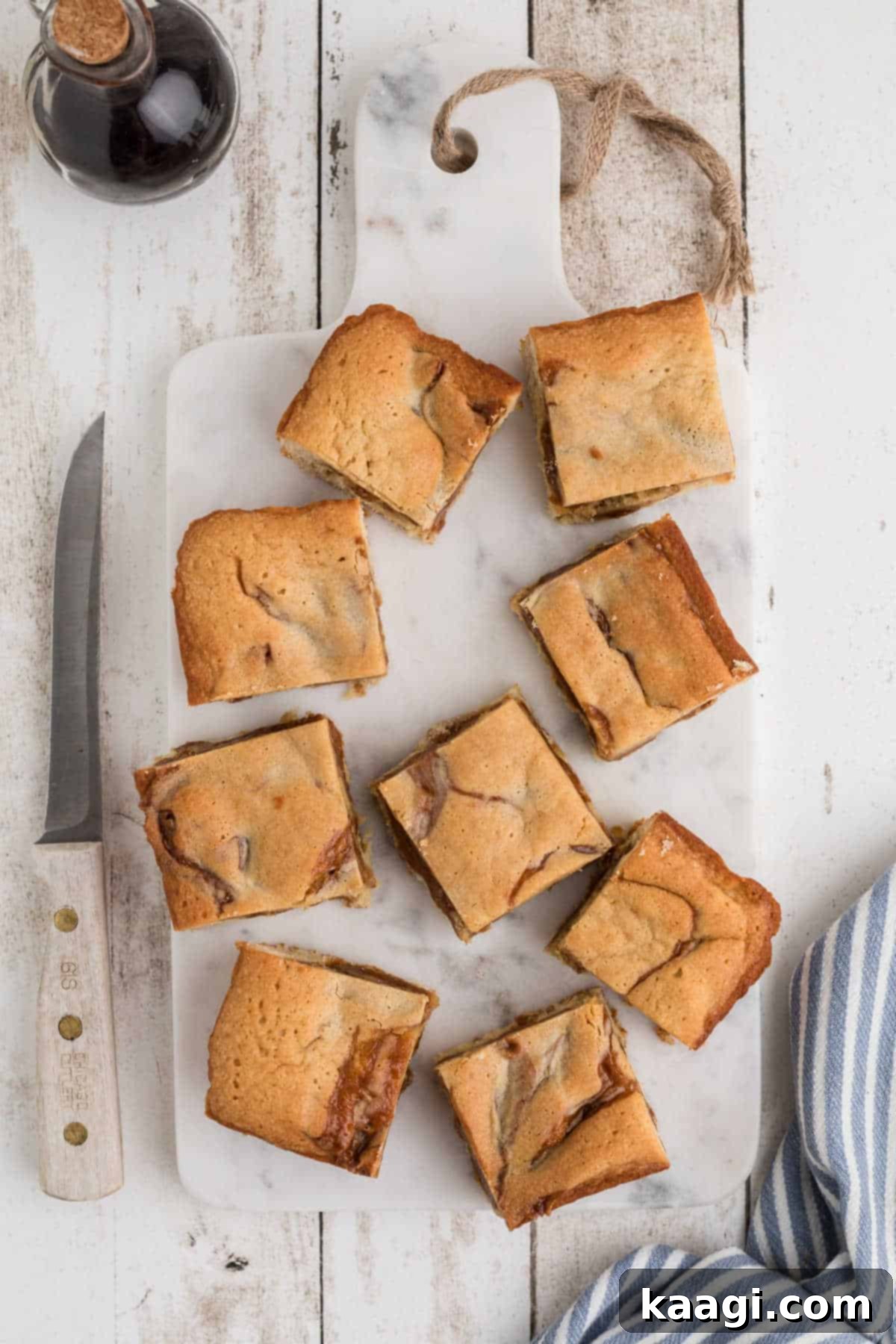 Caramel-Swirled Blondie Squares 2 Overhead view of several perfectly cut caramel swirl blondies arranged on a elegant granite board, highlighting their golden brown edges and distinct caramel marbling.