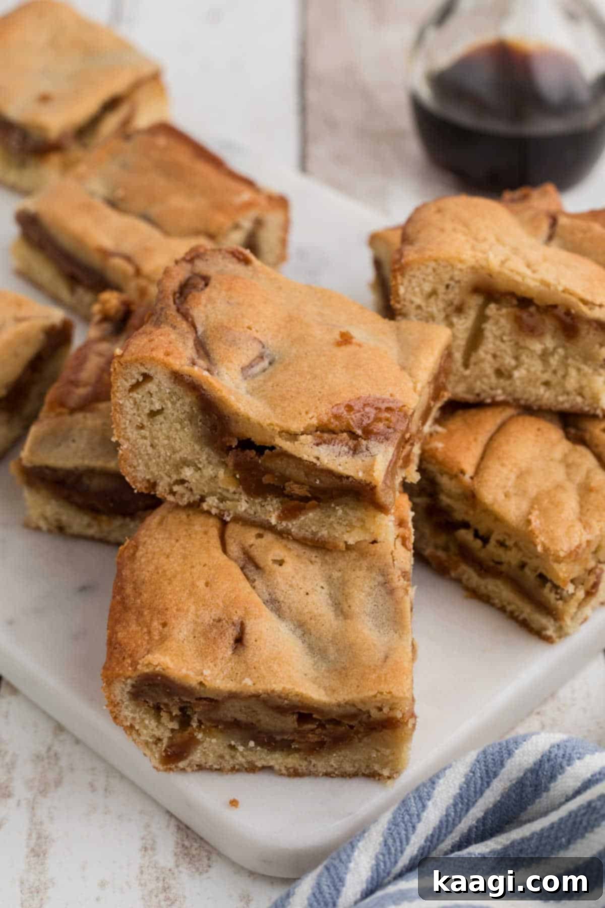 Caramel-Swirled Blondie Squares 9 Side view of some caramel blondies, beautifully stacked on each other, showing their thickness and rich caramel layers.