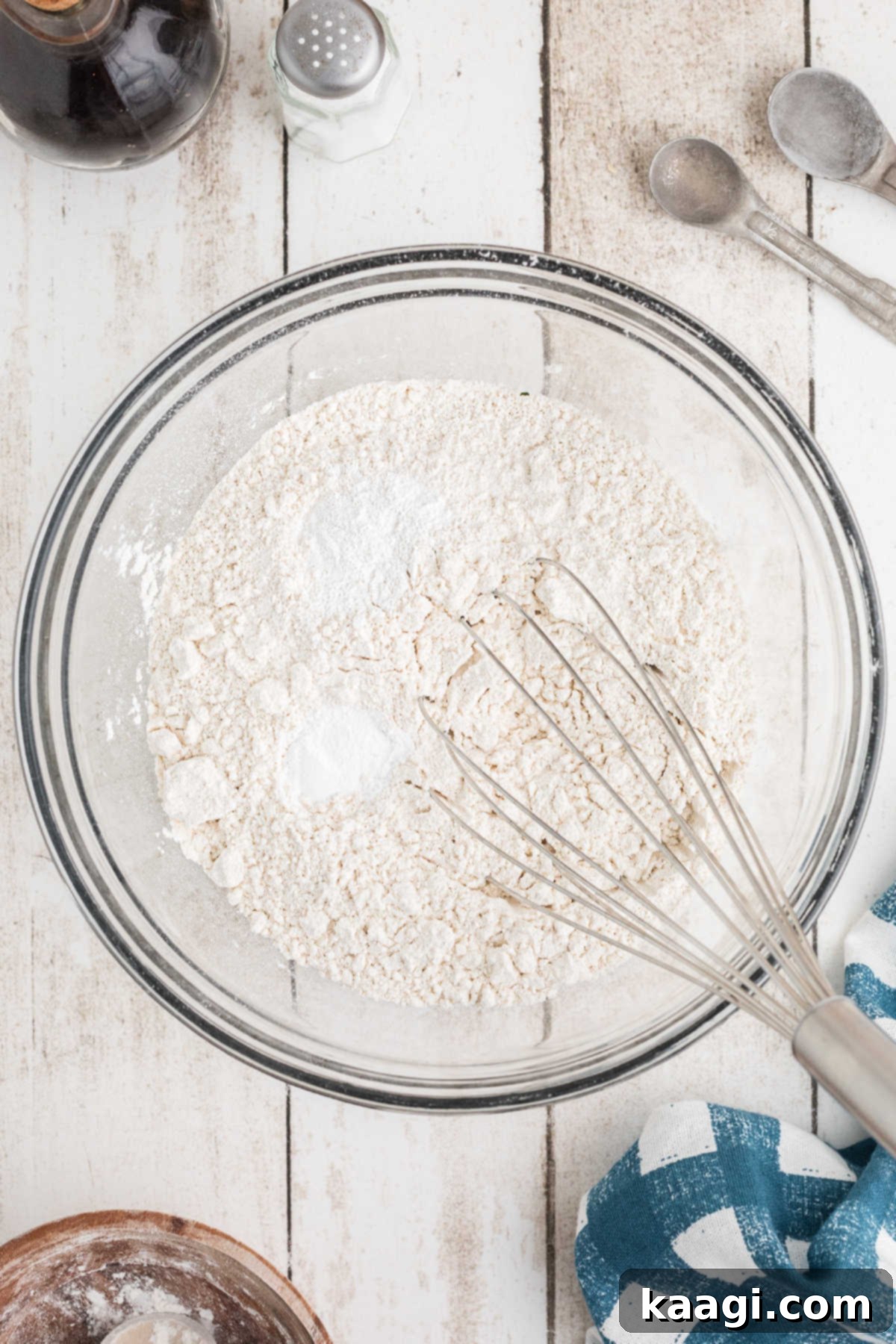 Flour and baking soda being whisked together in a separate bowl.