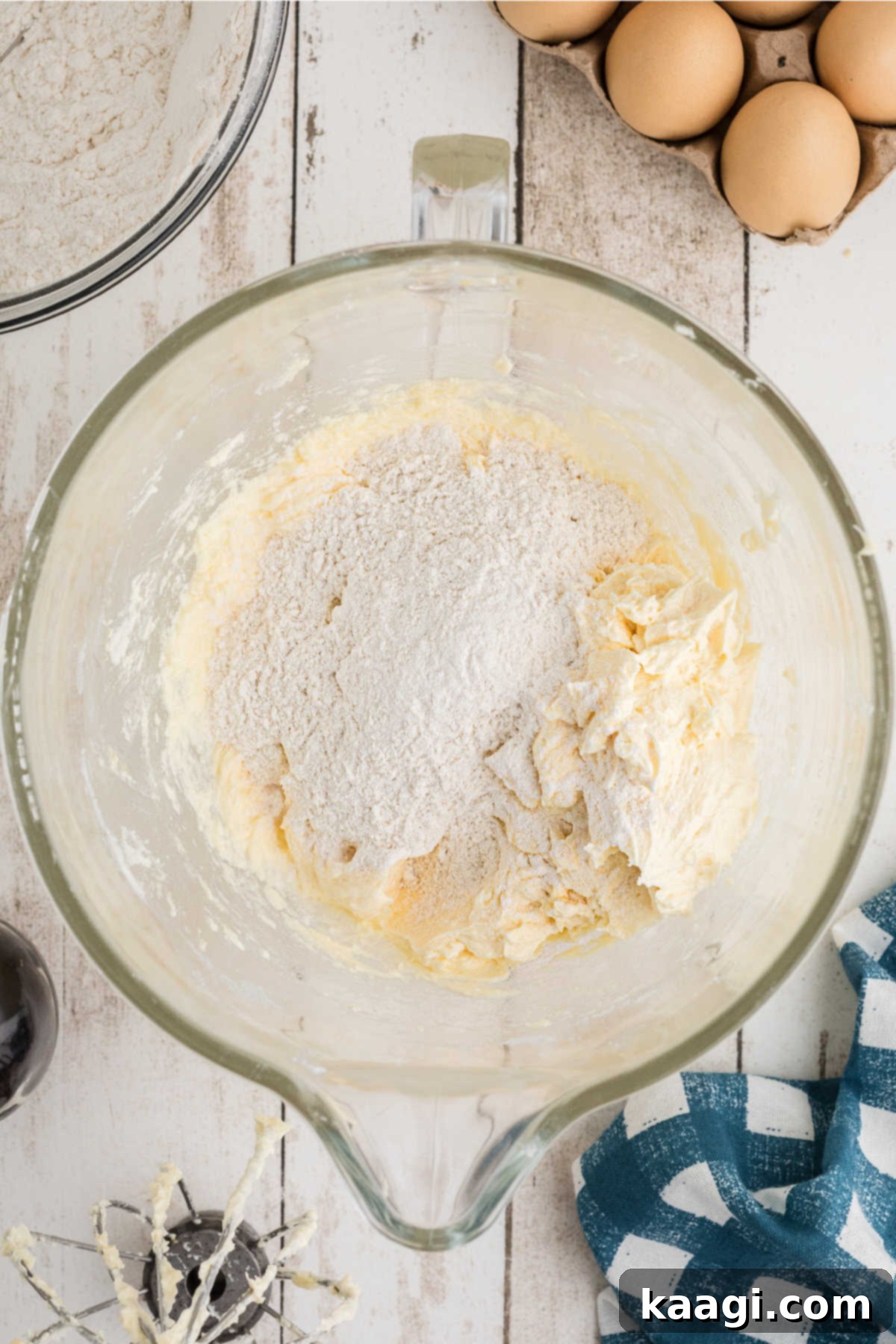 Dry ingredients slowly being mixed with the wet batter in a mixing bowl.