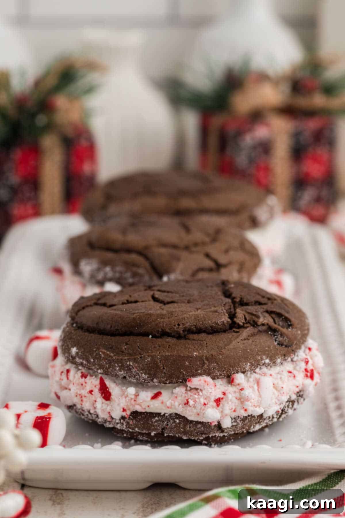 A straight on side image of some Christmas Whoopie Pies with some Christmas decorations in the background.