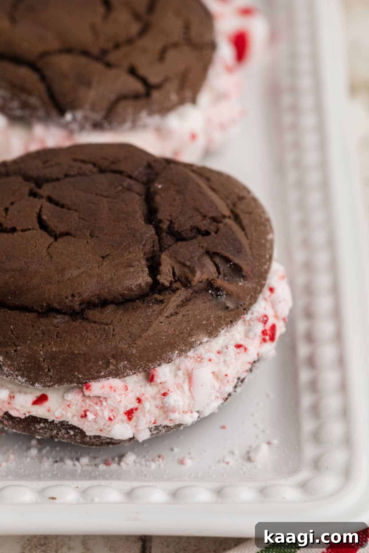 A close up side shot of some Christmas Whoopie Pies with crumbled peppermint candy.