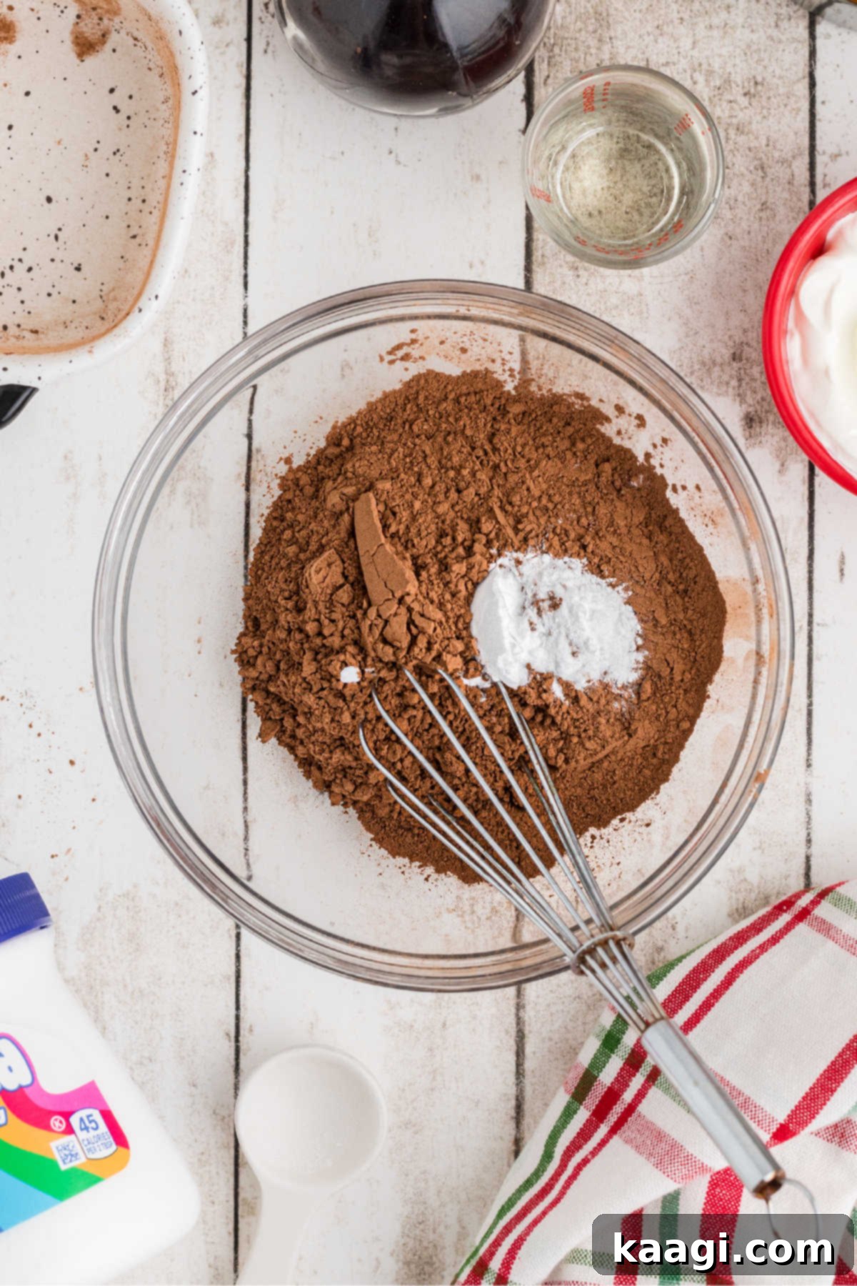A mixing bowl with cocoa powder and baking soda about to be mixed.