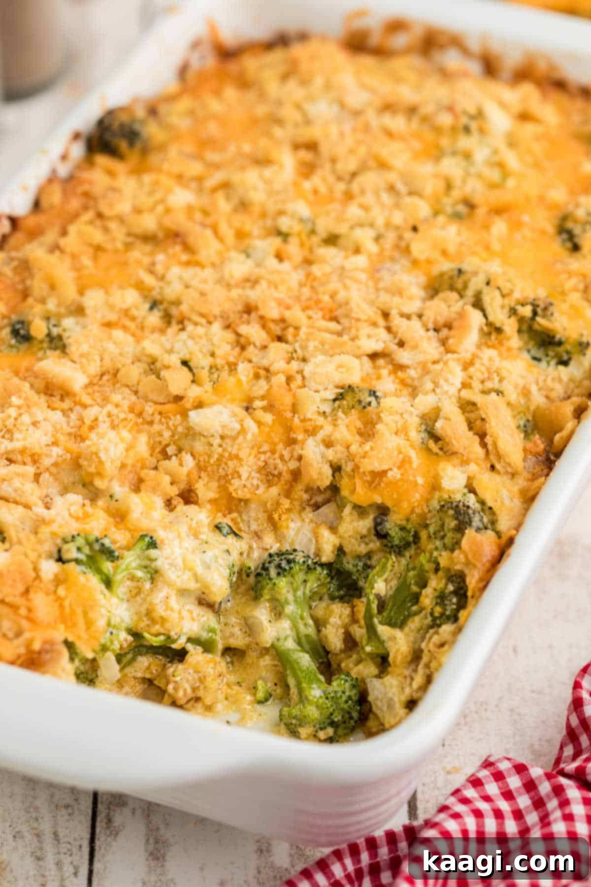 Golden Broccoli Bake 2 A golden-brown broccoli casserole dish with a corner scoop missing, showcasing the creamy, cheesy interior and tender broccoli florets.