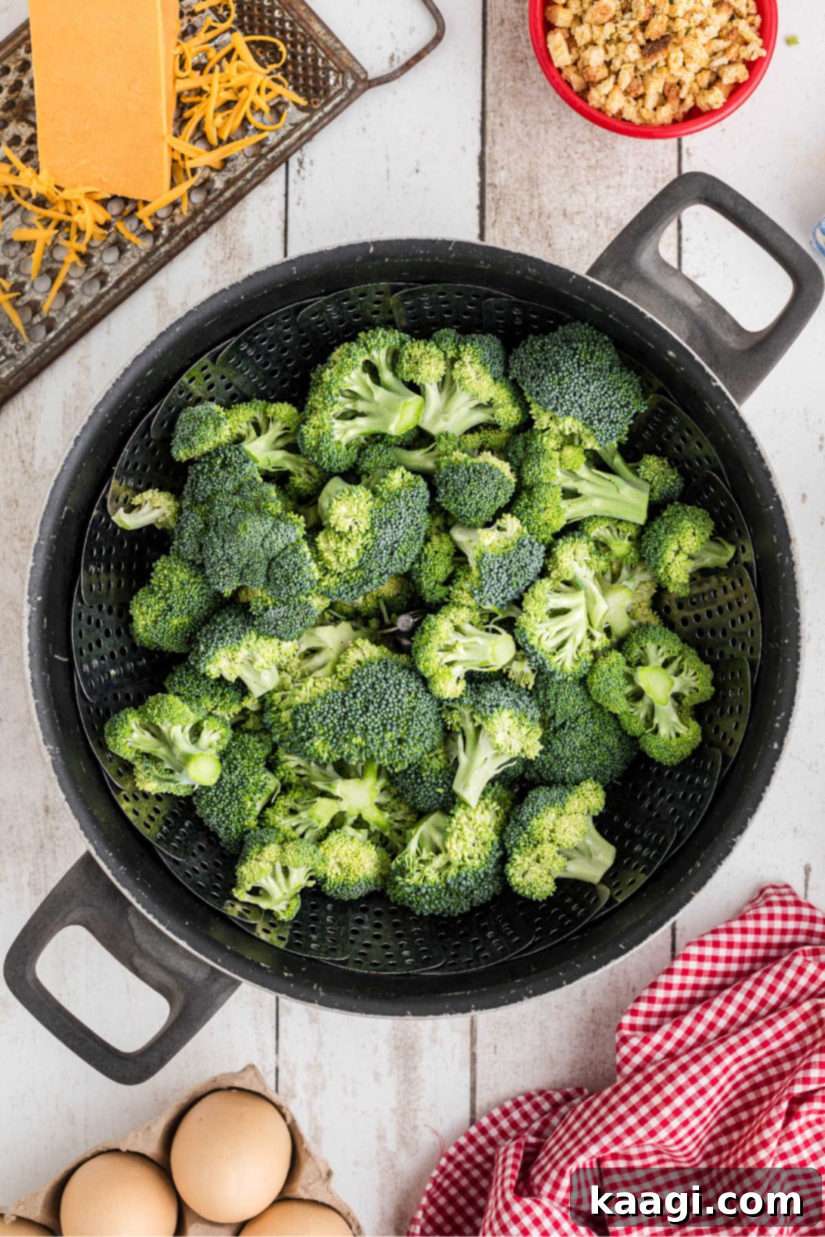 Golden Broccoli Bake 4 Fresh broccoli florets being steamed in a pot with a steaming basket, preparing them for the casserole mixture.