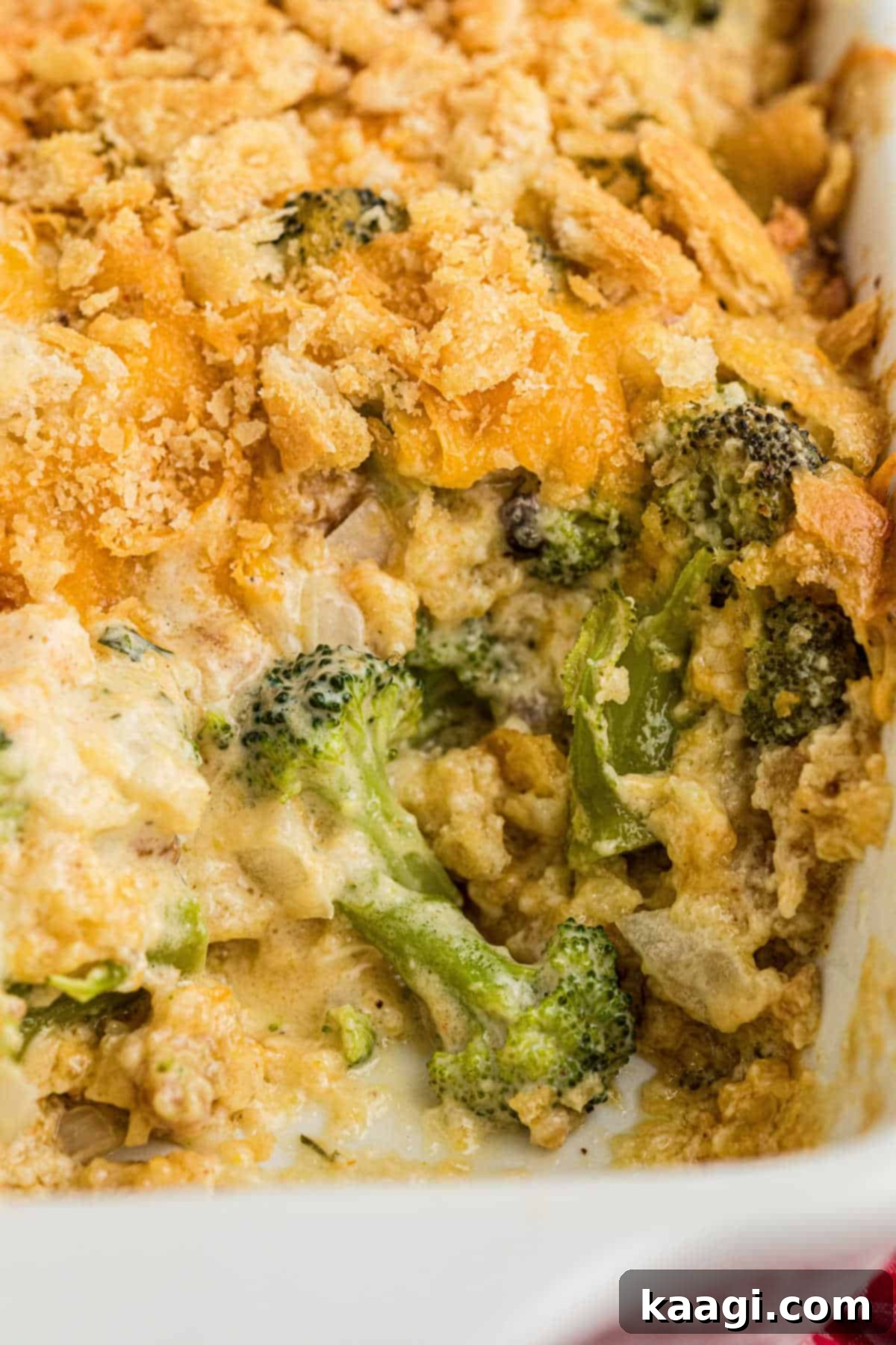 A close-up view of a baked broccoli casserole, with a portion scooped out, highlighting the rich, creamy texture.