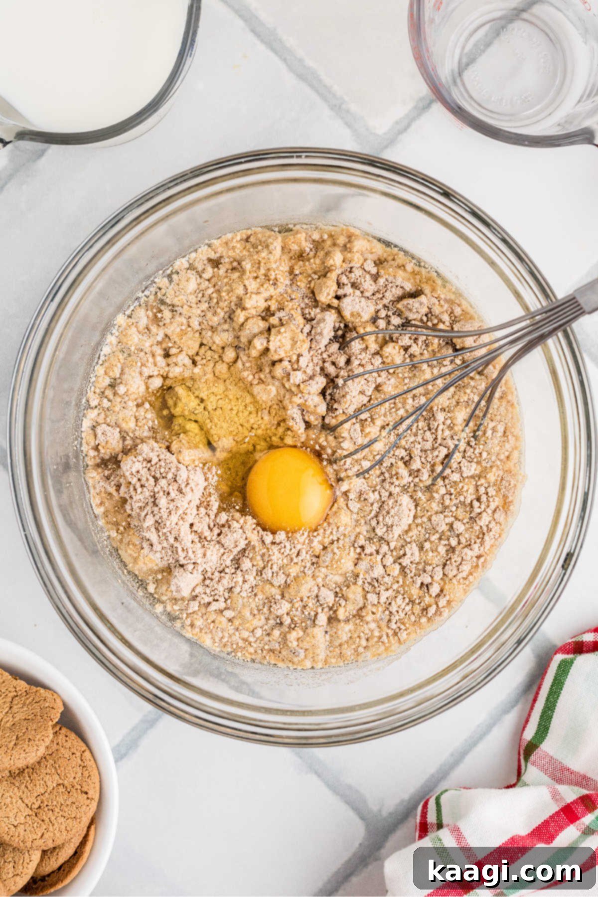 Cake mix, egg, and water in a glass mixing bowl, ready to be beaten.