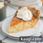 A slice of coconut pie with some cream squirted on top.