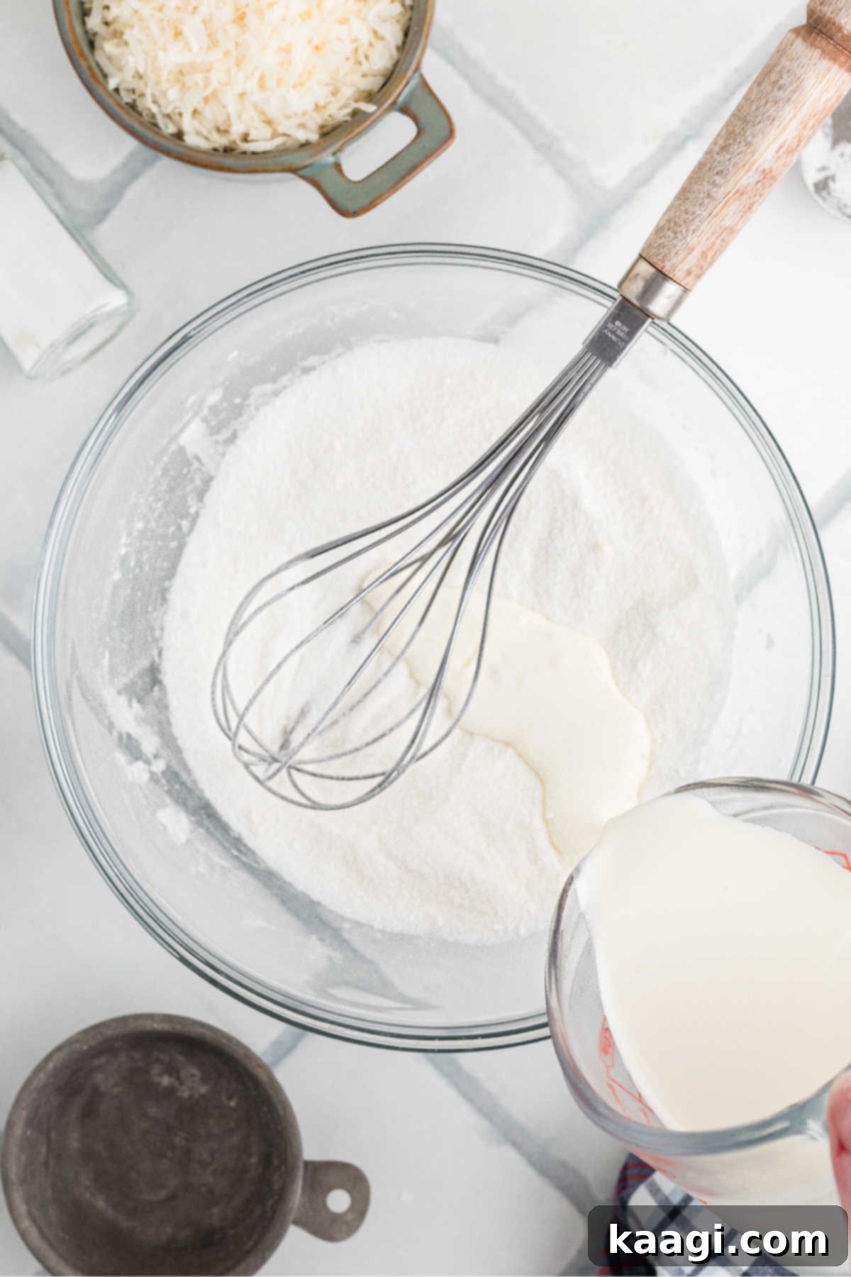 Heirloom Coconut Delight 5 Heavy whipping cream being steadily poured into a mixing bowl already containing sugar and cornstarch, ready for mixing.