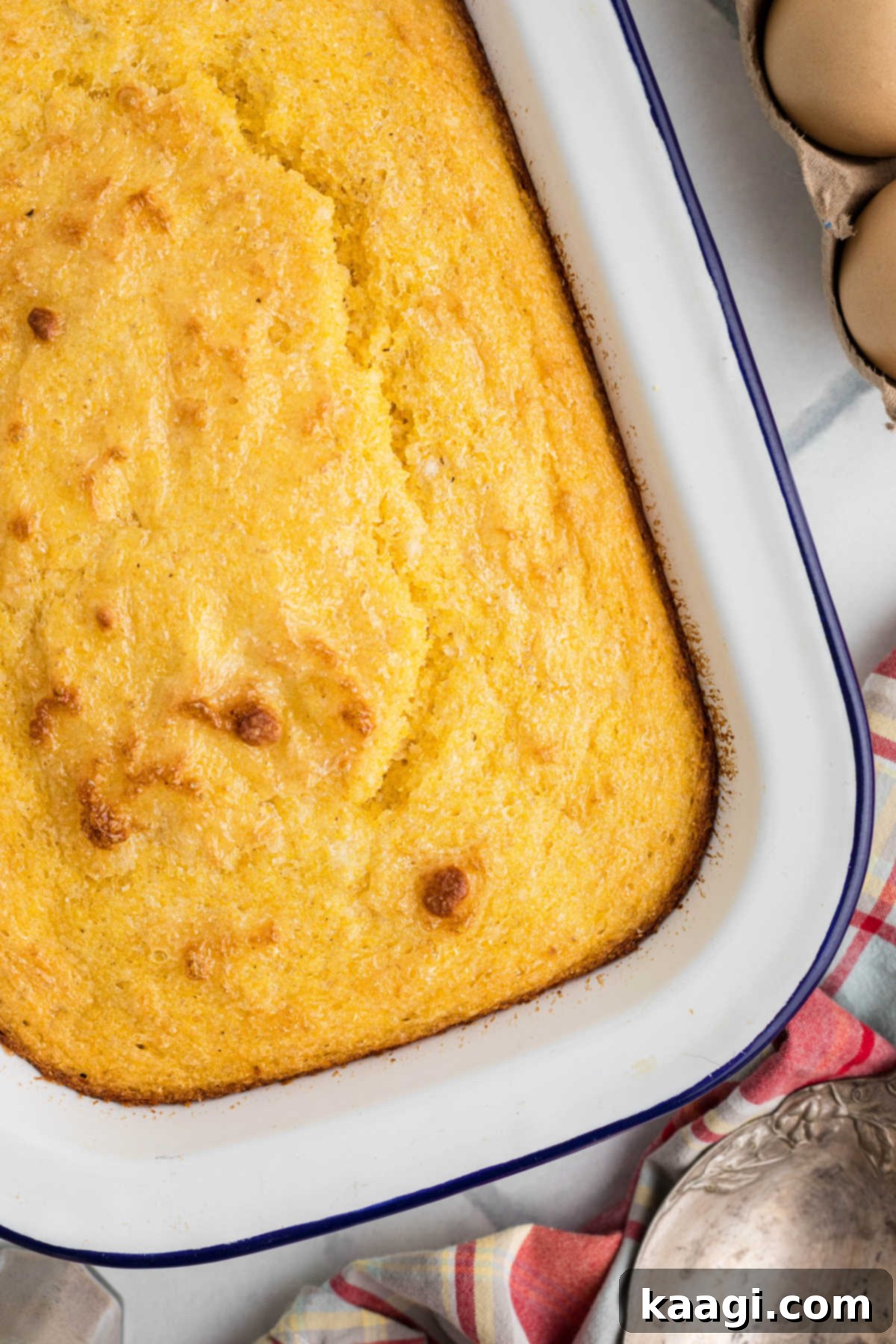 Overhead shot of a pan full of old fashioned southern spoon bread, showing its golden crust and fluffy texture.