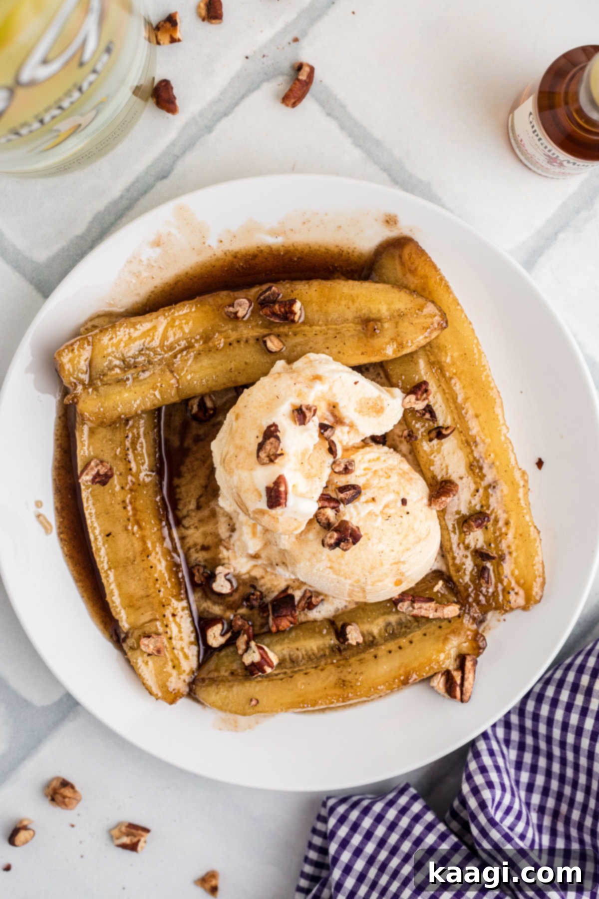 Overhead shot of a plate of Bananas Foster, with some ice cream in the middle and toasted pecans.