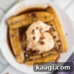 Overhead shot of a plate of Bananas Foster with a dollop of ice cream in the middle.