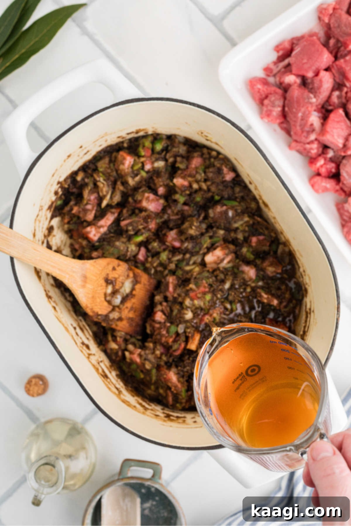 Soulful Southern Beef Gumbo 8 Beef broth being poured into a large pot with other ingredients.