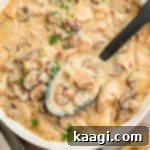 Louisiana Chicken Stroganoff 13 Close up overhead of a pan of Cajun chicken stroganoff, with a spoon digging in.