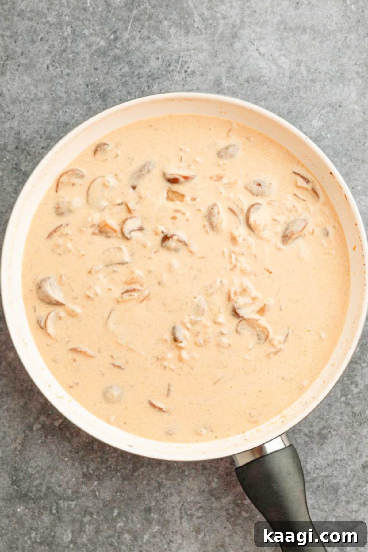 Louisiana Chicken Stroganoff 7 Cream being added to a large skillet.