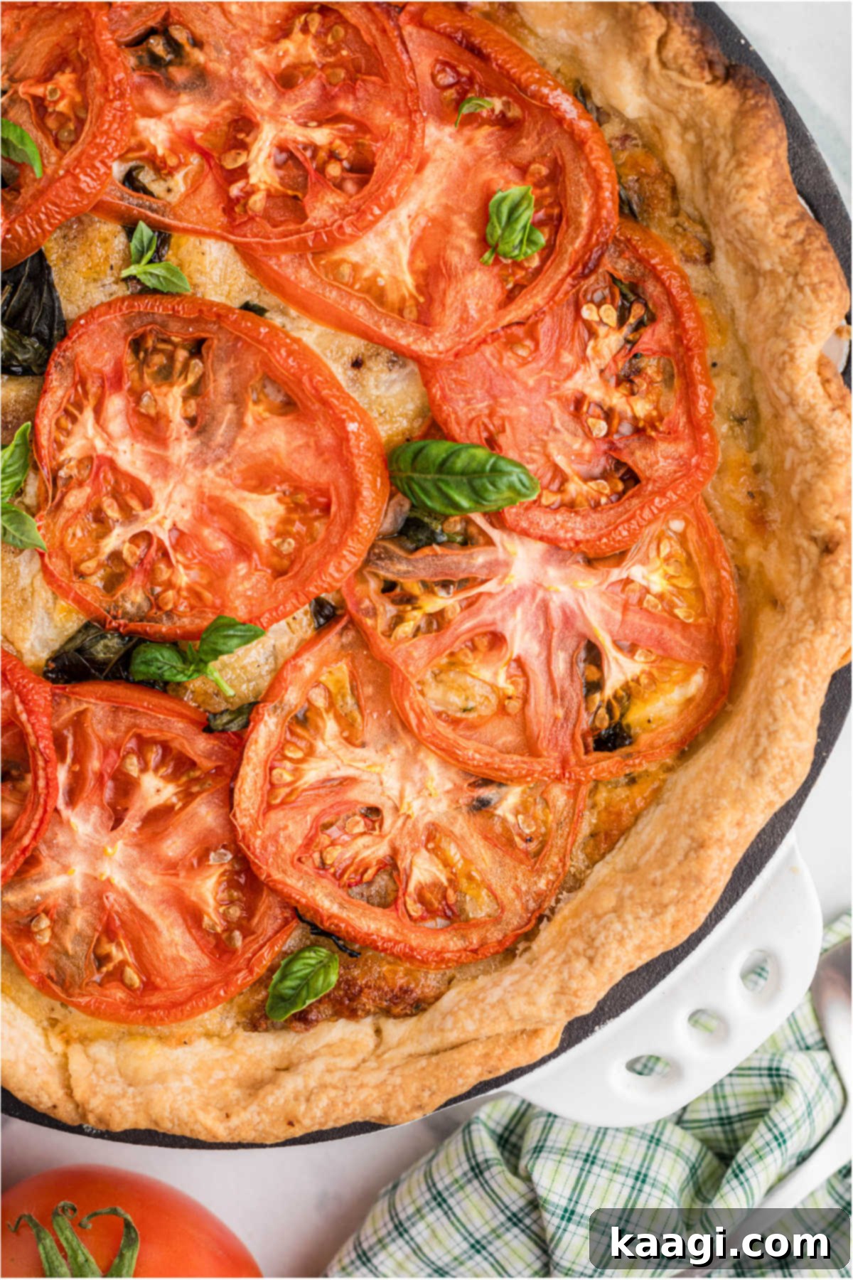 Dixie Tomato Tart 9 A golden-brown baked tomato pie, fresh out of the oven, with perfectly arranged tomato slices on top, ready to cool and be served.
