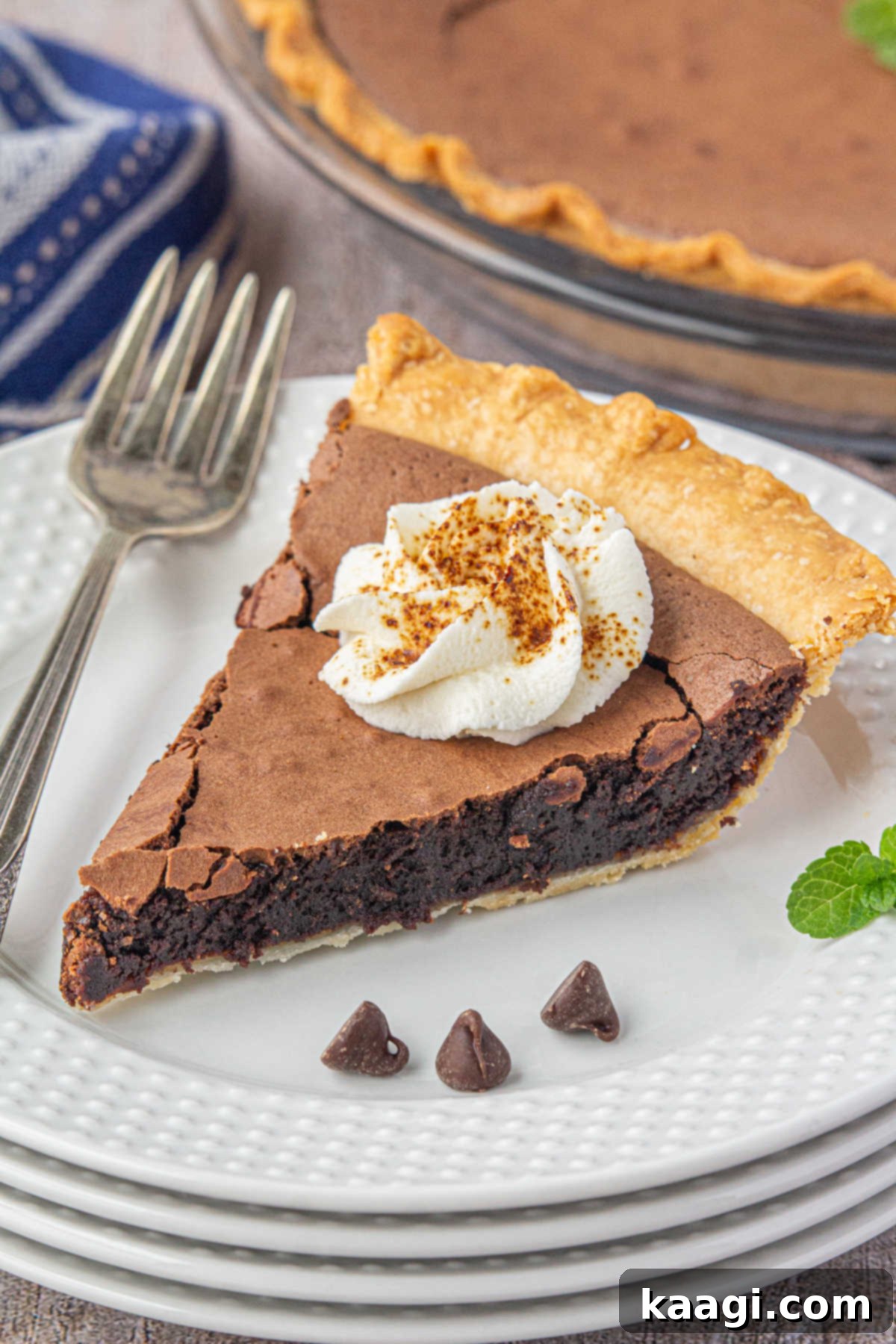 A stack of white dishes with a tempting slice of Southern Chocolate Chess Pie perched elegantly on top, signifying the end of a delightful meal.