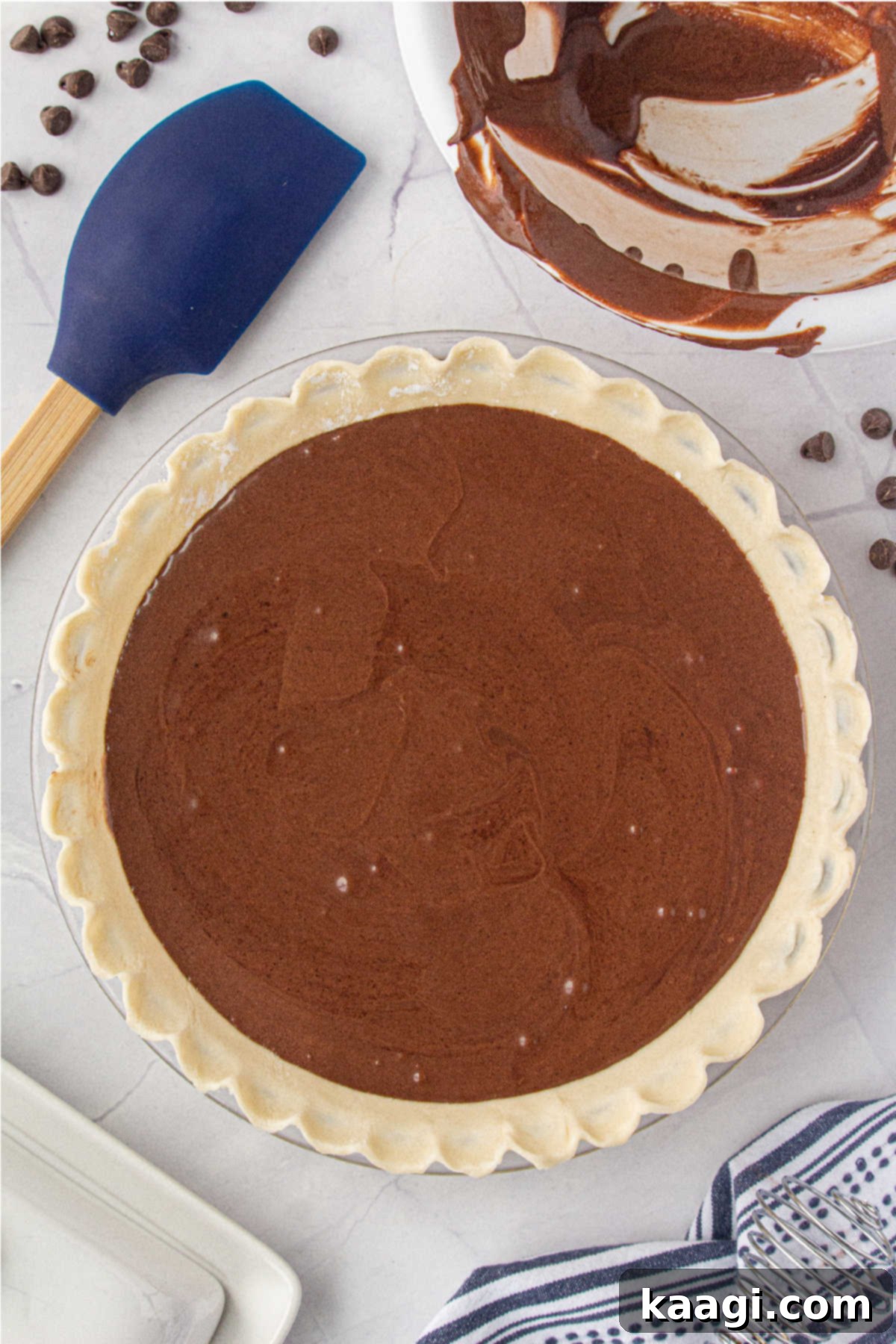 The dark, rich chocolate pie filling is gently poured into the chilled, unbaked pie crust, filling it almost to the brim.
