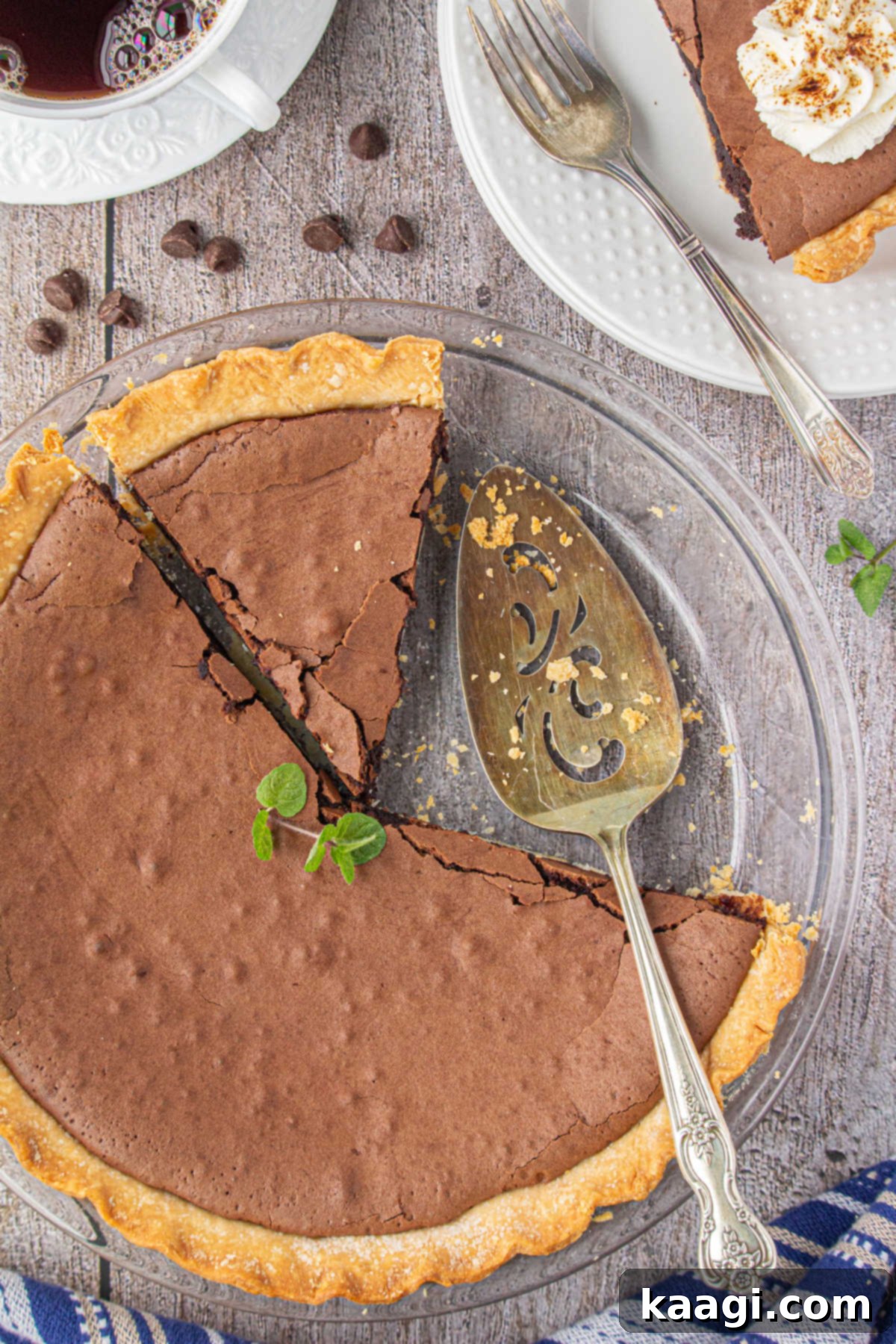 An overhead shot of a golden-brown pie dish, holding a freshly baked Southern Chocolate Chess Pie with a slice elegantly removed.