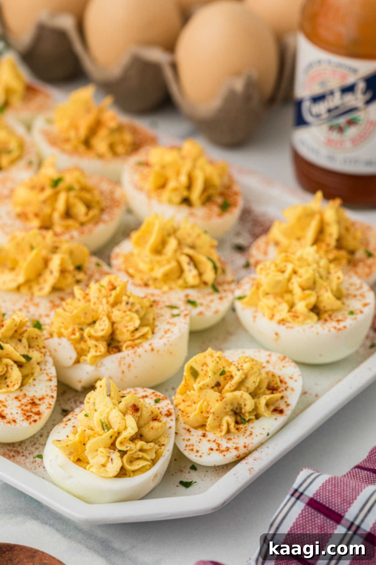 Fiery Cajun Deviled Eggs 2 A side on shot of a plate full of Cajun deviled eggs, garnished with paprika.
