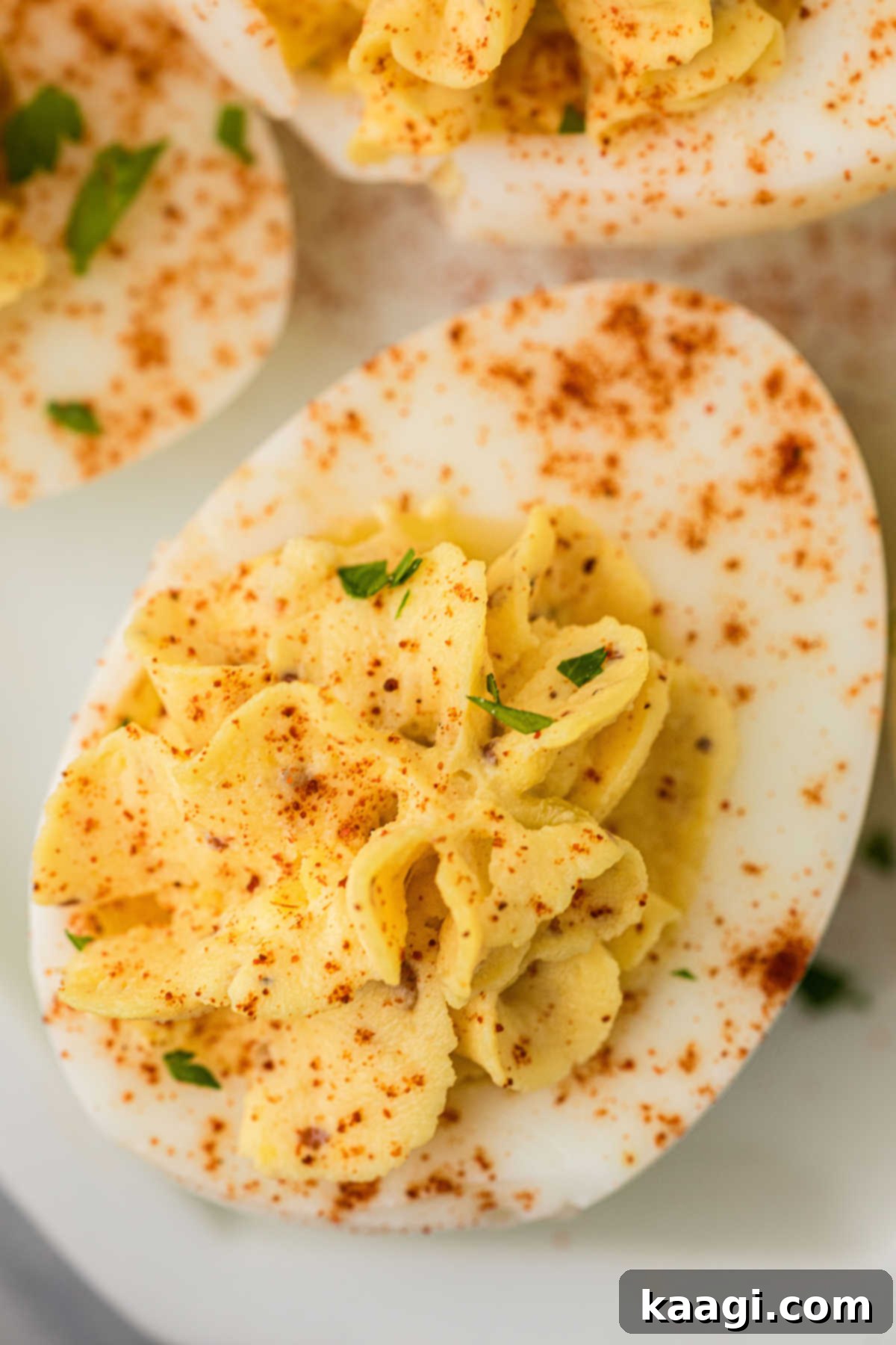 Fiery Cajun Deviled Eggs 7 Close up shot of a single Cajun deviled egg, showing the creamy filling and paprika garnish.
