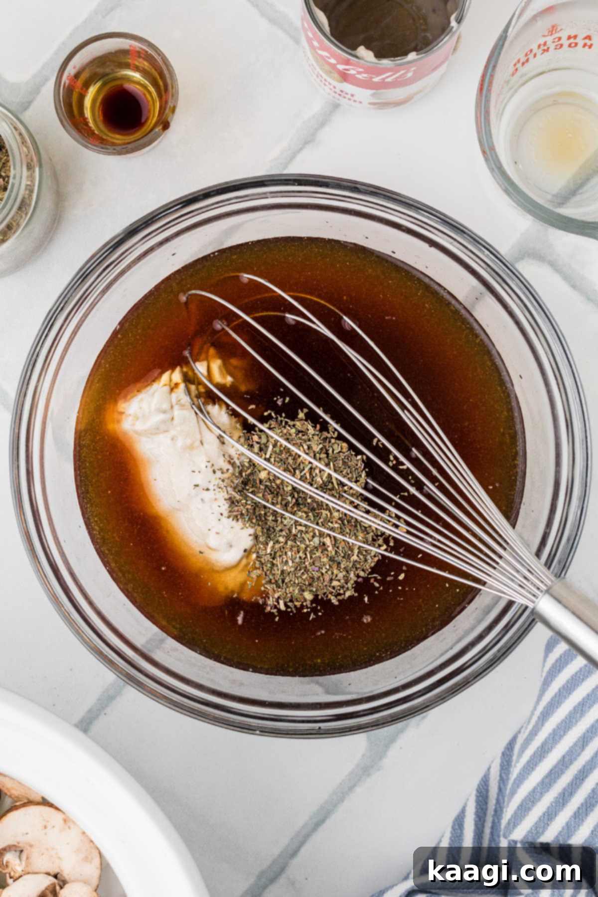 A large mixing bowl filled with beef broth and seasoning.