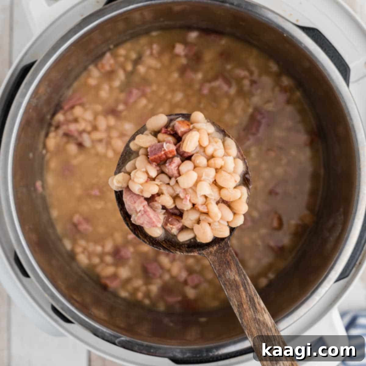 Elevate Your Plate with Essential Southern Sides 26 Creamy white beans resting on a spoon over an Instant Pot, ready to be served.