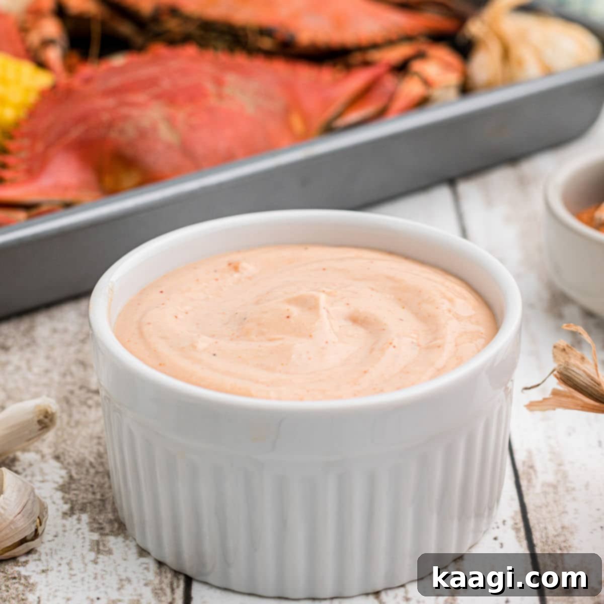 Elevate Your Plate with Essential Southern Sides 41 A inviting bowl of flavorful seafood sauce with some freshly boiled crabs visible in the background.