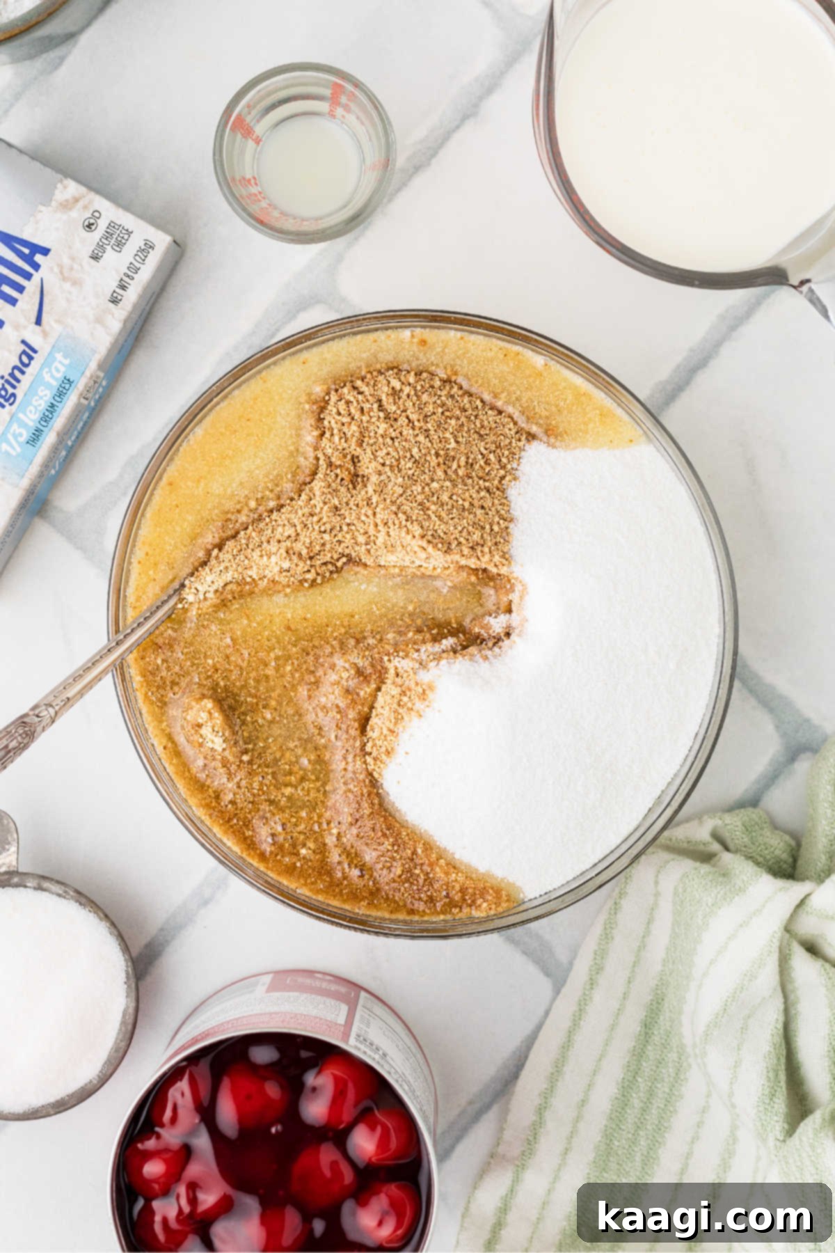 A large mixing bowl full of melted butter, graham cracker crumbs and sugar, thoroughly combined.