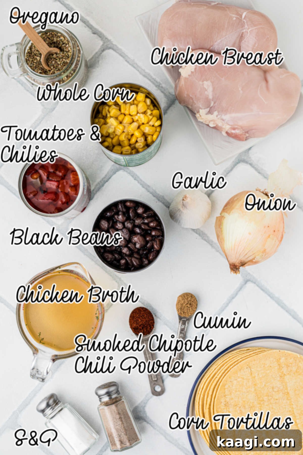 An overhead view of the fresh and canned ingredients needed to make a slow cooker chicken tortilla soup recipe, neatly arranged on a counter.