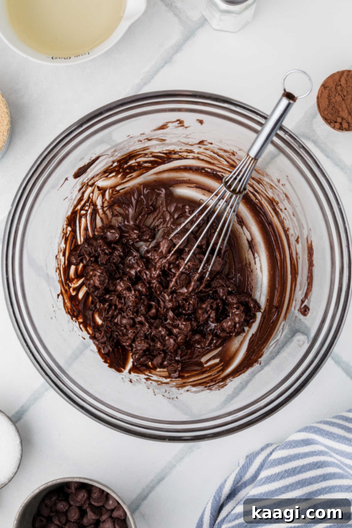 A large glass mixing bowl where semi-sweet chocolate chips are in the process of being melted, ready for the next step of the pie filling.