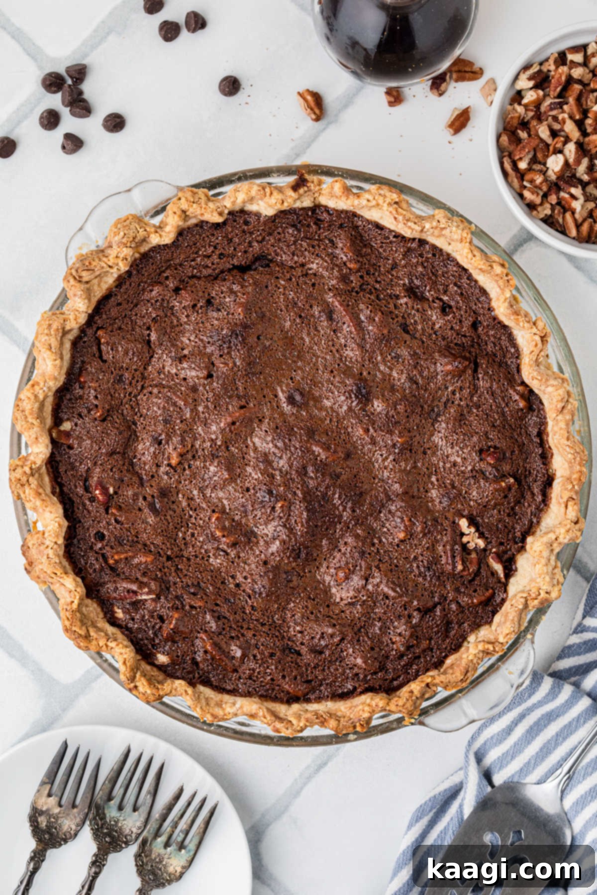 An inviting overhead view of a perfectly baked, glistening chocolate pecan pie, showcasing its rich, dark filling and golden pecan topping.