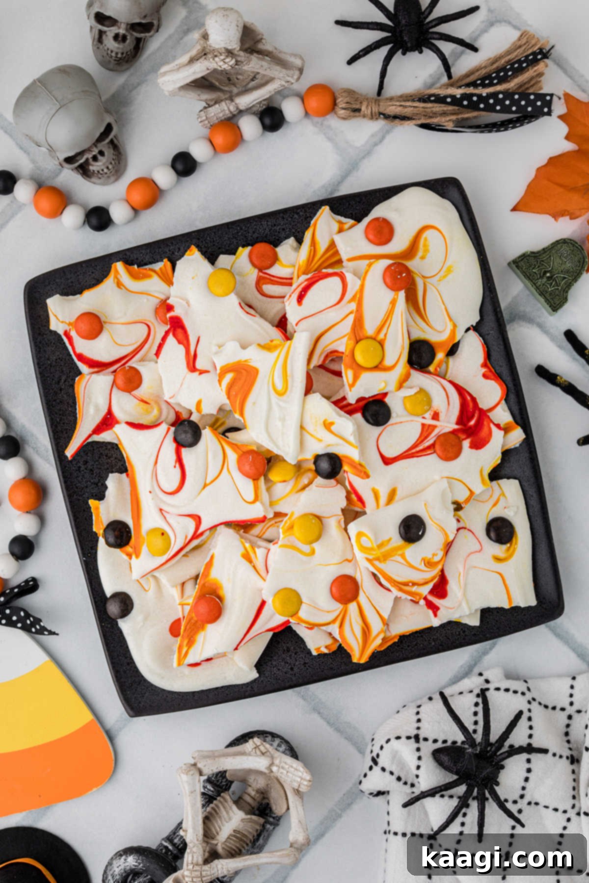 Creepy Crunch Bark 2 An overhead picture of Halloween bark, decorated with spooky decorations all around, featuring warm fall colors like orange, gold, and brown.