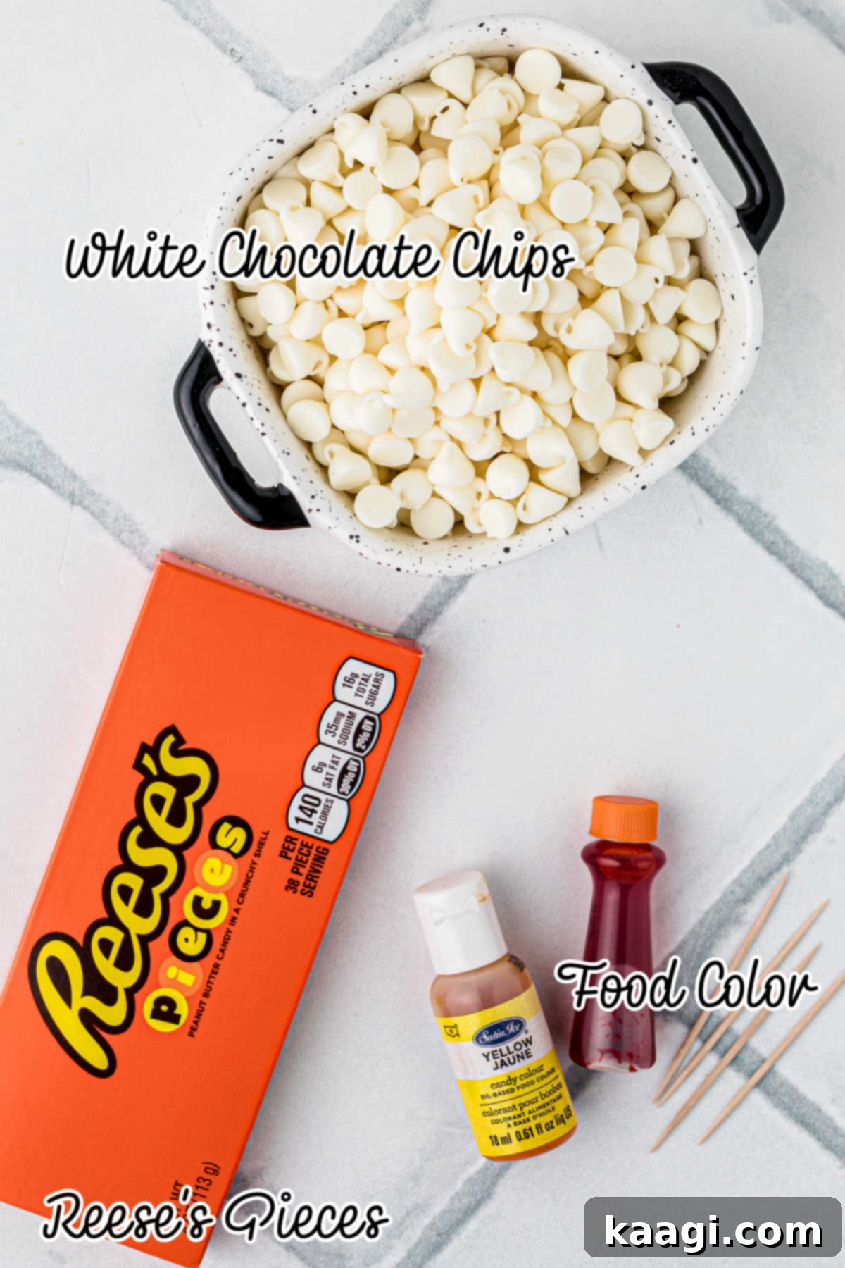Creepy Crunch Bark 3 Overhead shot of white chocolate chips, Reese's Pieces candy, and food coloring bottles, ready to be used for making Halloween bark.