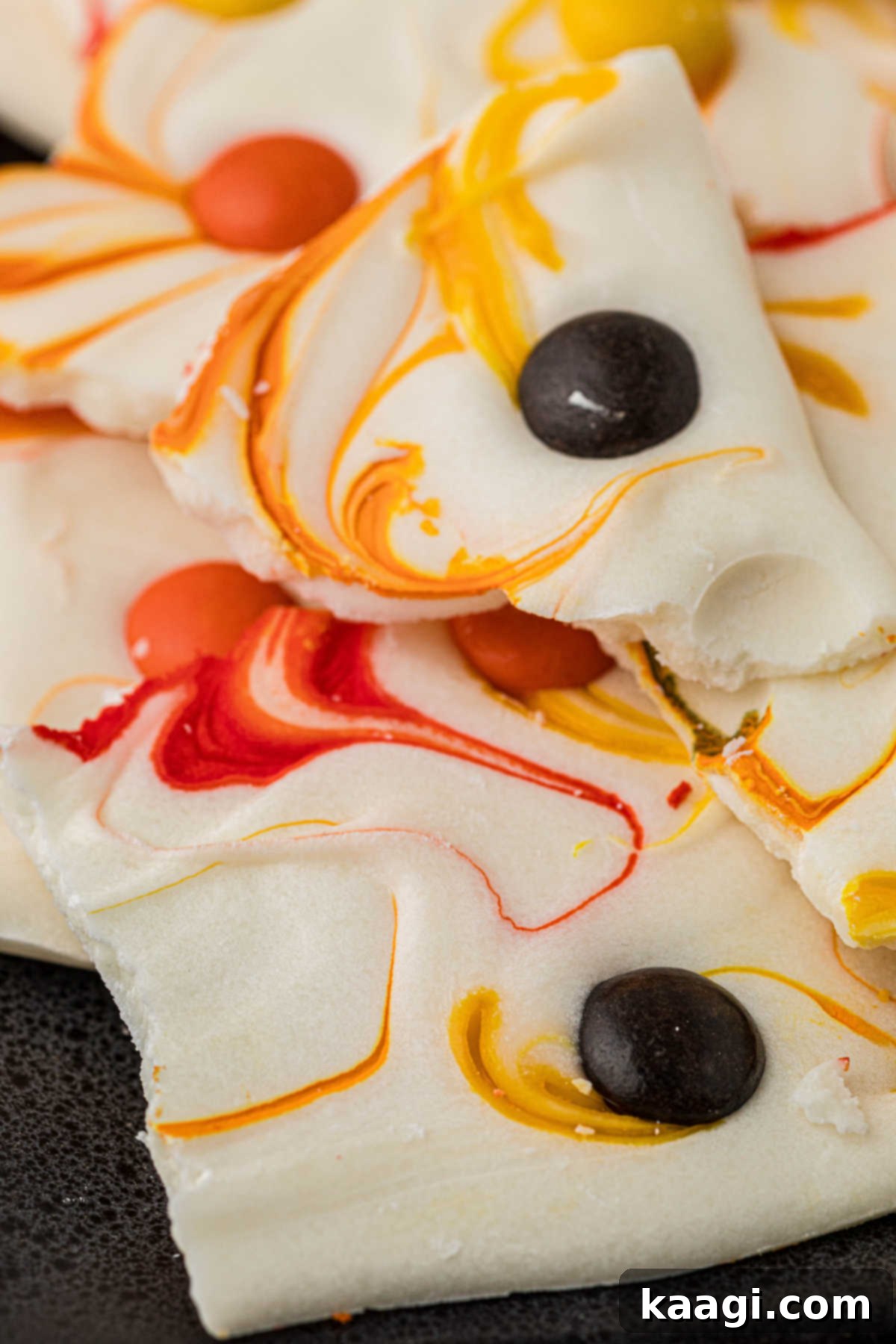 Creepy Crunch Bark 9 A very close-up picture of the finished Halloween bark, broken into irregular pieces, showing the swirled colors and embedded candies.