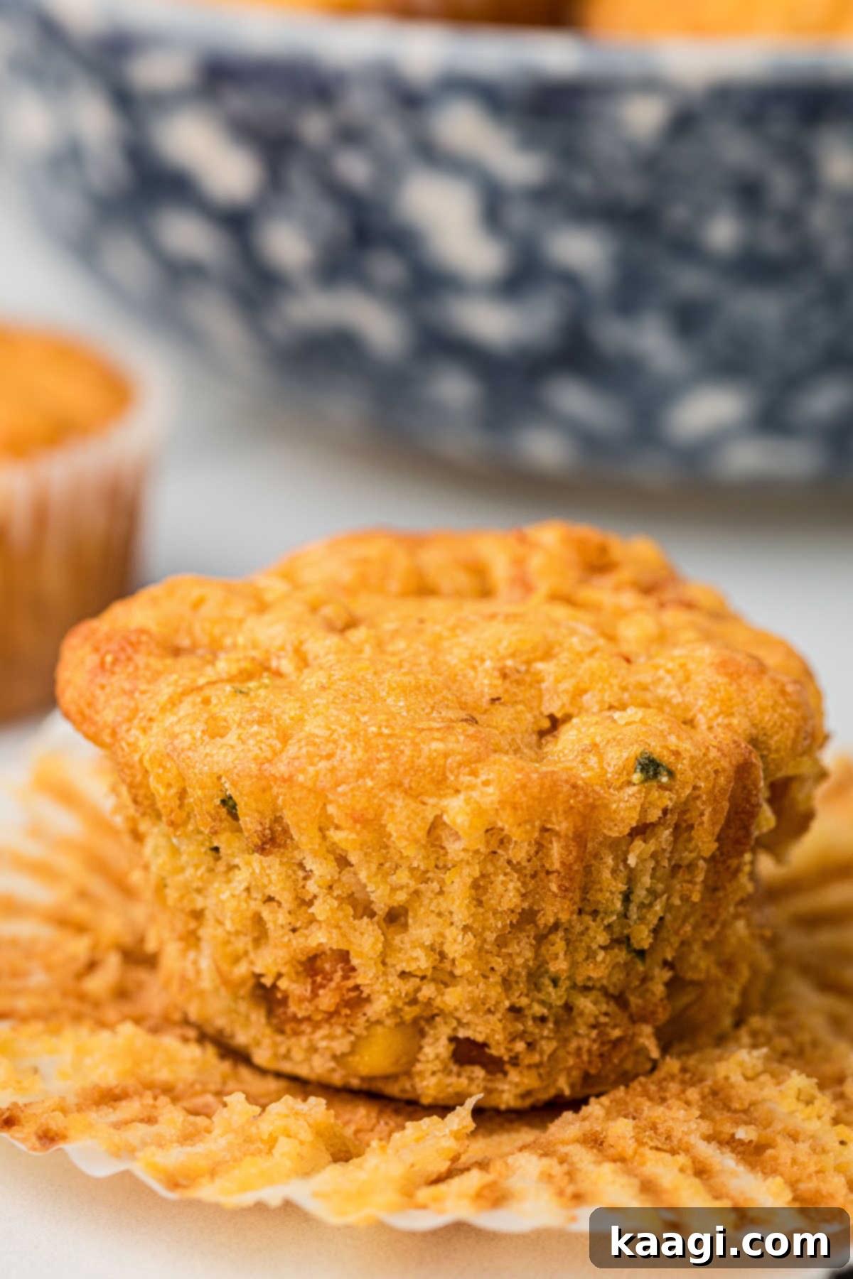 Cajun Crawfish Cornbread Muffins 11 A freshly baked crawfish cornbread muffin, with its paper liner carefully and cleanly removed, beautifully showcasing its perfectly golden-brown exterior and inviting, tender texture.