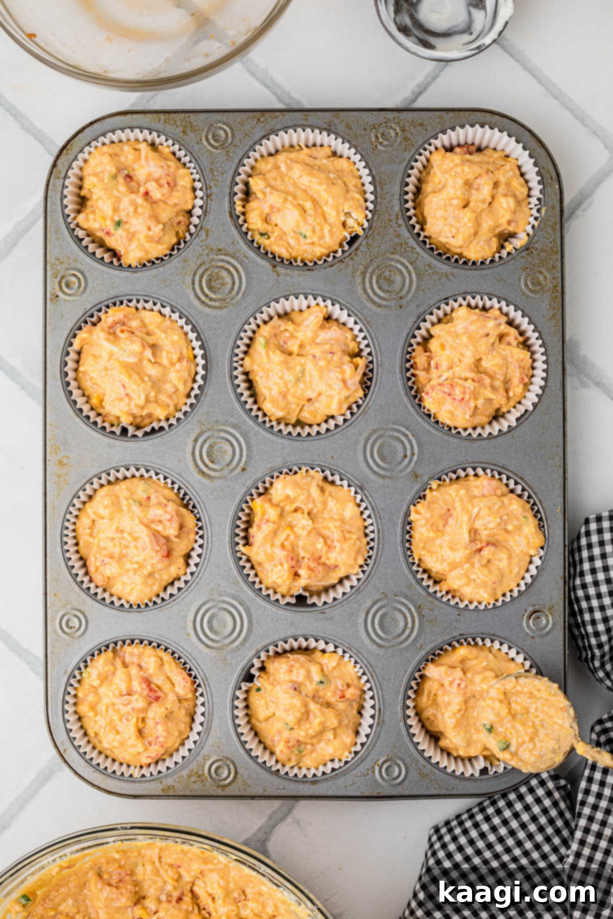 Bayou Crawfish Cornbread Muffins 8 A muffin pan filled with crawfish cornbread mix.
