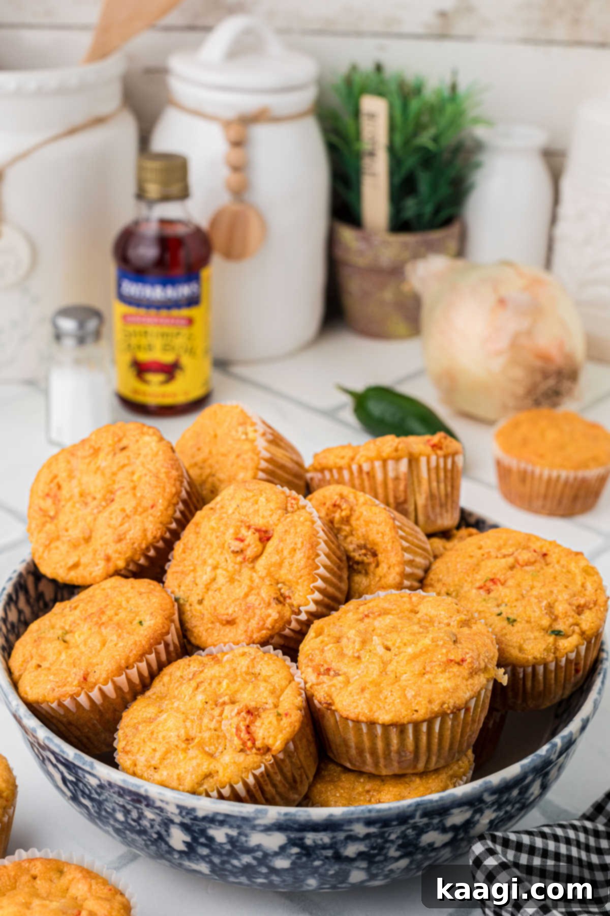 Cajun Crawfish Cornbread Muffins 9 A large, rustic ceramic bowl generously filled with numerous freshly baked, golden-brown crawfish cornbread muffins, steam gently rising from them, indicating they are hot and ready to be served and enjoyed immediately.