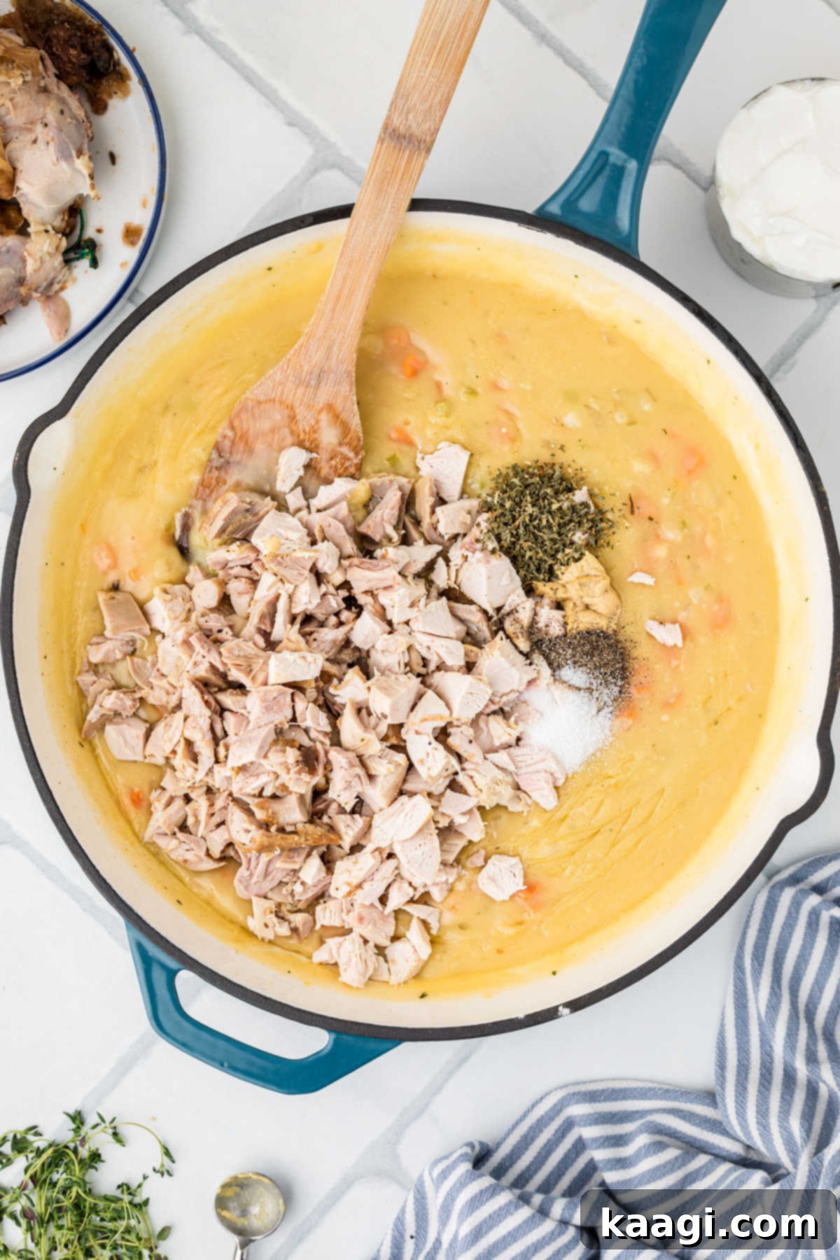 Comforting Mini Chicken Pot Pies 11 A large skillet with a gravy-like filling, chopped chicken, Dijon mustard, dried parsley, and fresh thyme added.