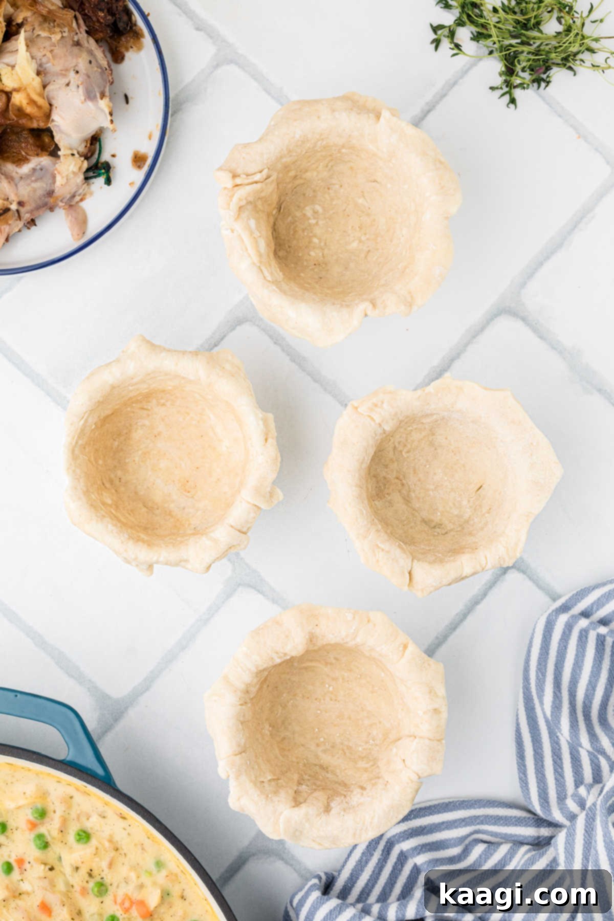 Comforting Mini Chicken Pot Pies 13 Four ramekin dishes with pie dough pressed into them, ready for filling.