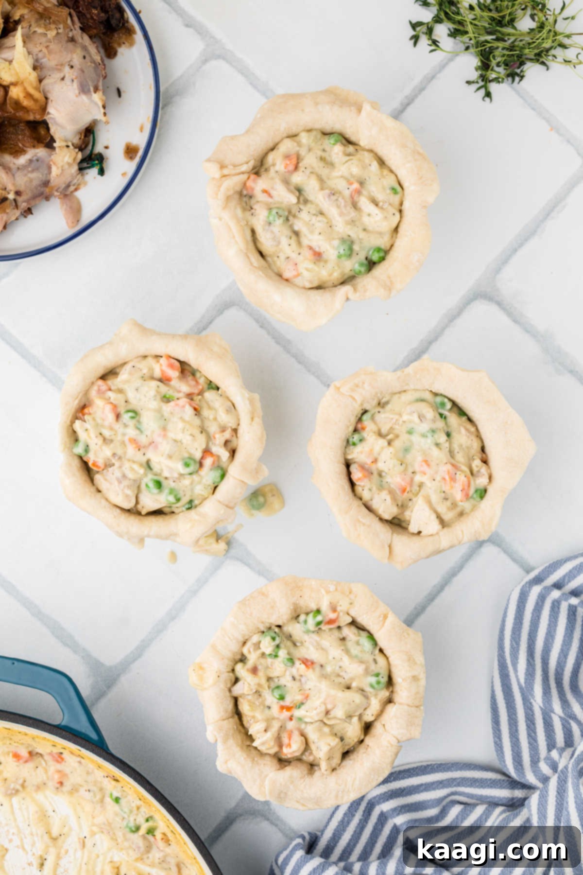 Comforting Mini Chicken Pot Pies 14 Chicken pot pie filling being spooned into small individual mini pies lined with dough.