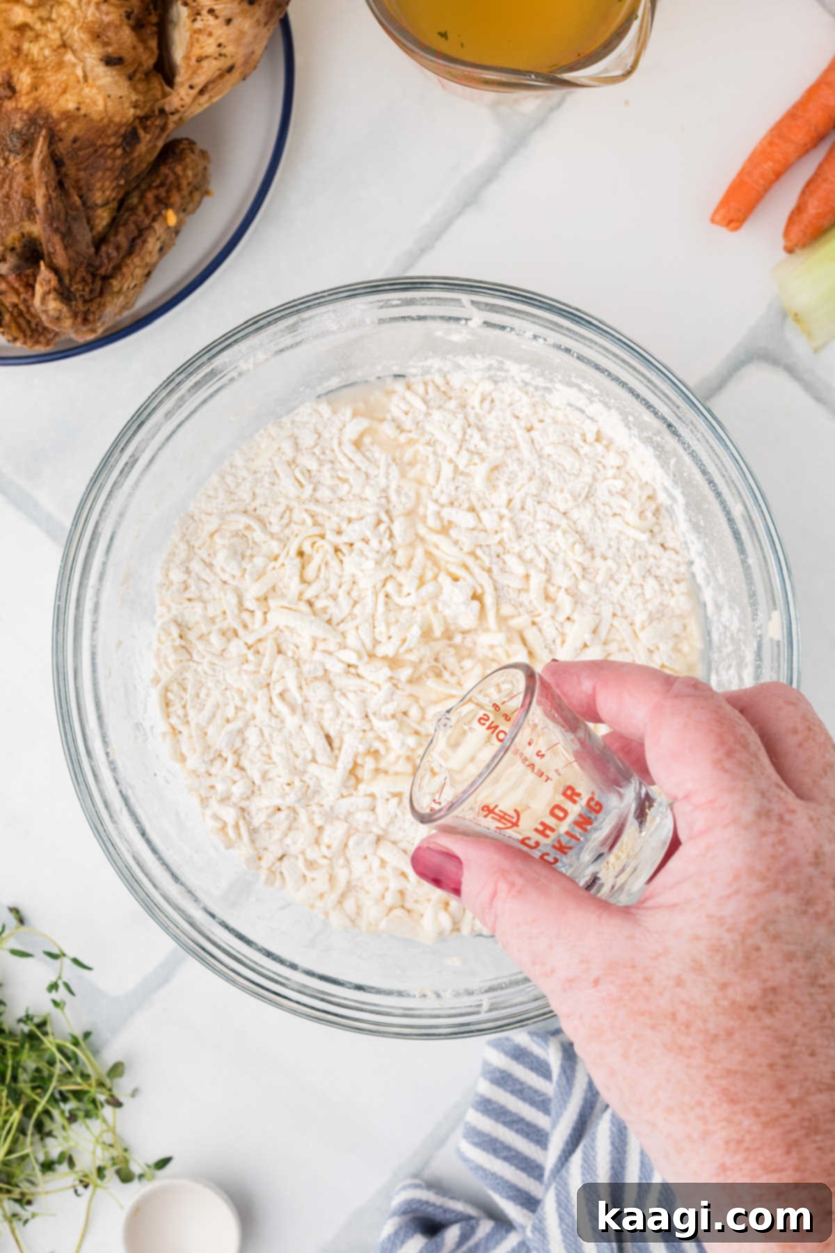 Comforting Mini Chicken Pot Pies 6 A small amount of iced water being added to a flour and butter mixture.