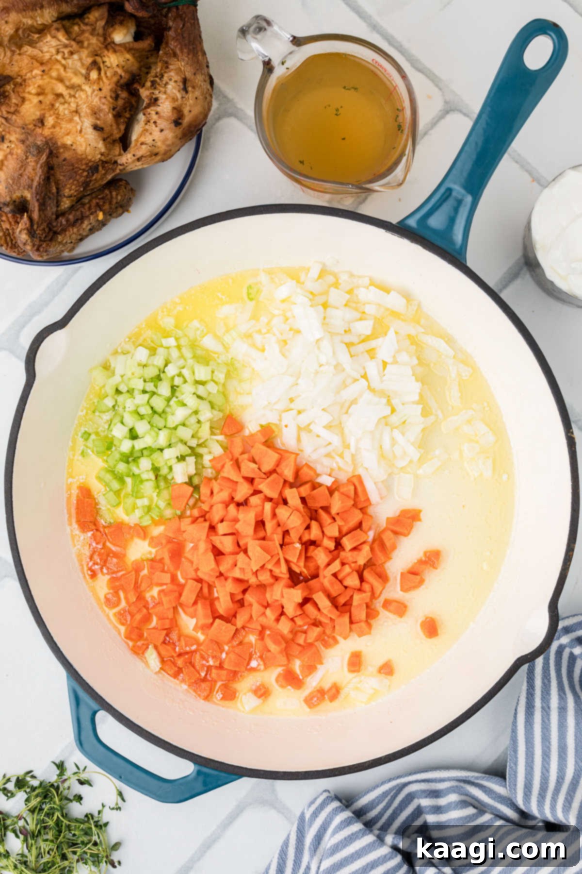 Comforting Mini Chicken Pot Pies 8 A large heavy skillet with melted butter, diced onions, carrots, and celery sautéing.