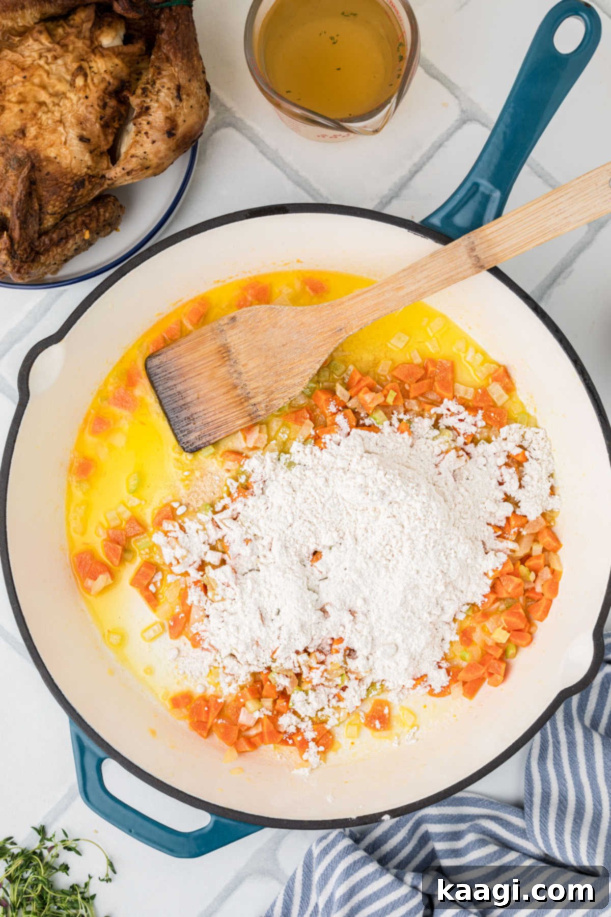 Comforting Mini Chicken Pot Pies 9 Flour added to a large heavy skillet with carrots, onions, and celery, forming a roux.