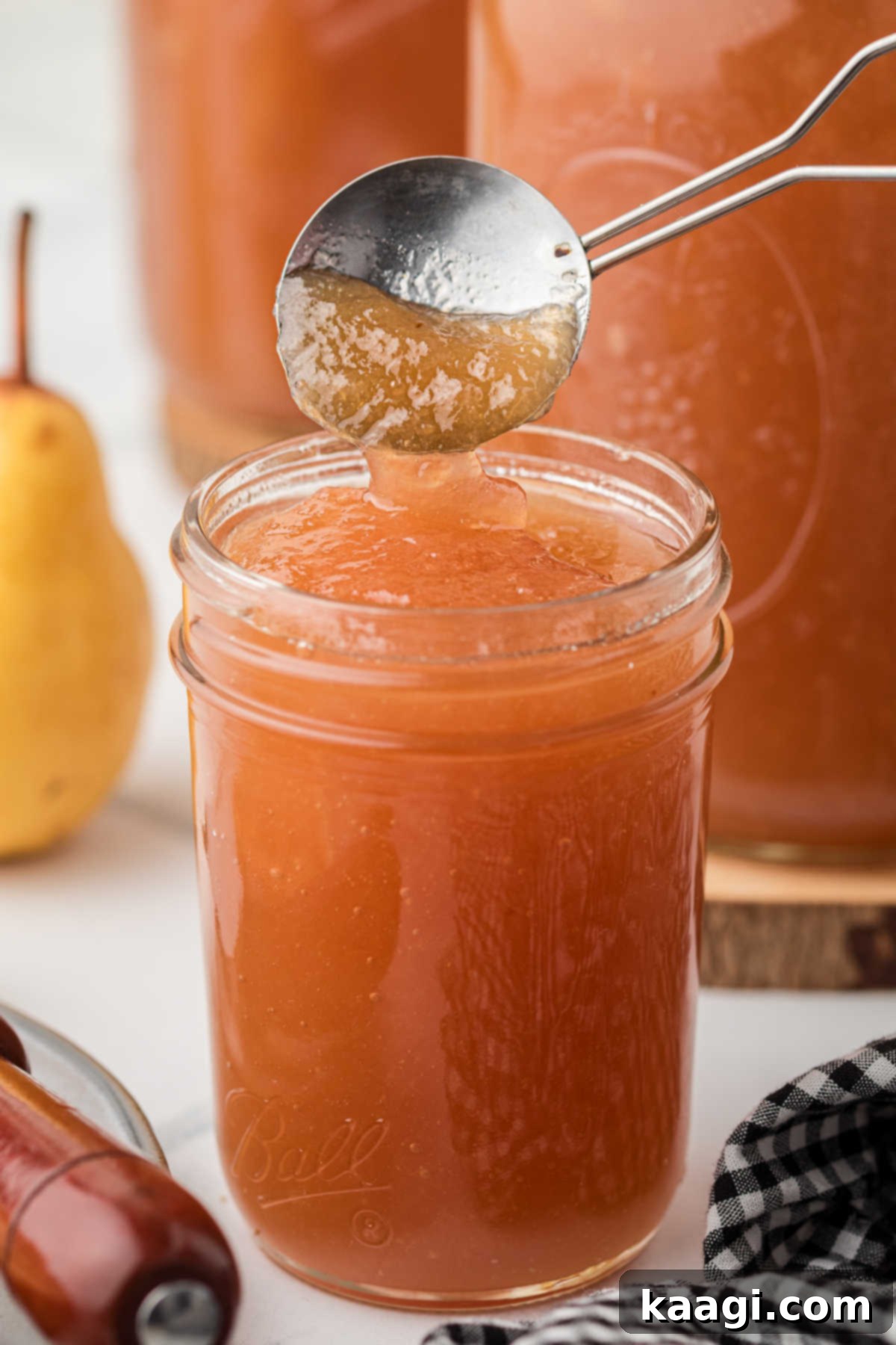 A jar of Amish Pear Honey with a spoon dipping in, ready to be enjoyed.