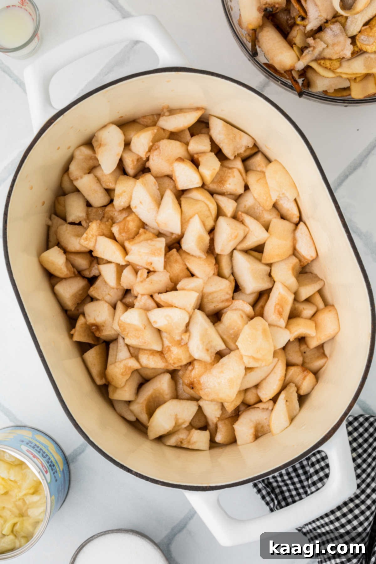 A large pot filled with pieces of pear, peeled and cored.